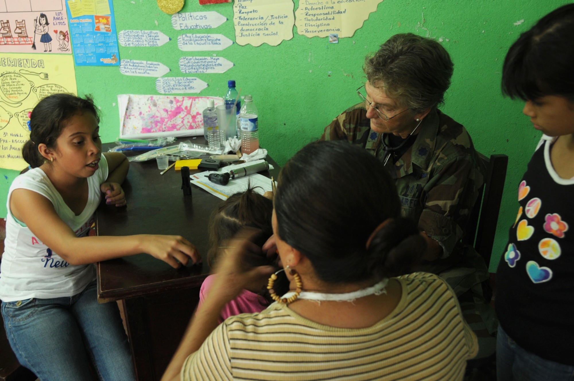 SEBACO, NICARAGUA -- Antonella Espinoza, a local 12-year-old student, helps translate Lt. Col. Iris Eisenberg's prescription instructions to a  mother and her children here Aug. 11, 2011 during the Medical Readiness Exercise, or MEDRETE. Eisenberg said Espinoza tripled her efficiency by helping her communicate with her patients. (USAF photo by Senior Airman Meredith A. H. Thomas, 916 ARW/PA)