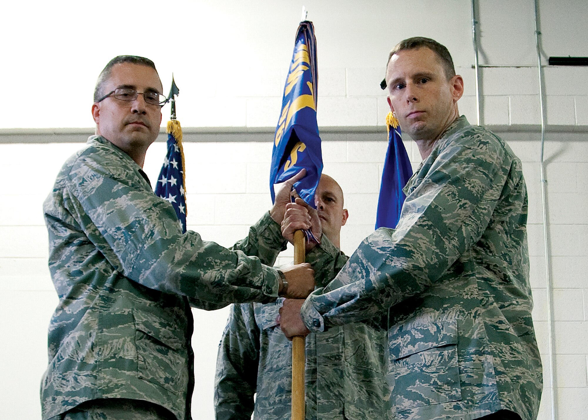 Lt. Col. Travis Leighton, 90th Civil Engineer Squadron commander, accepts the guidon from Col. Tim Dodge, 90th Mission Support Group commander, during the 90th Civil Engineer Squadron change-of–command ceremony Aug. 4. (U.S. Air Force photo by Matt Bilden)