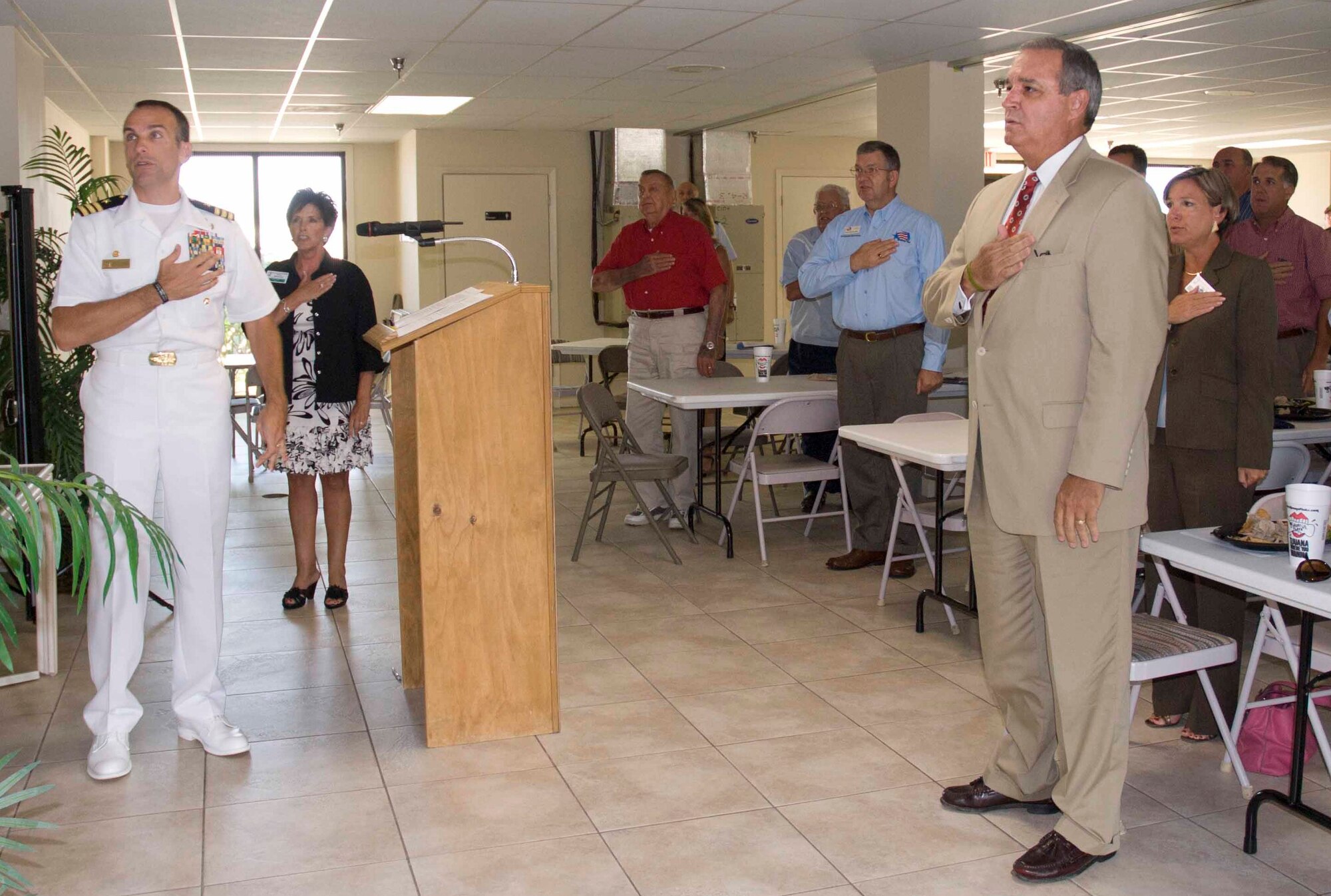 FORT WALTON BEACH, Fla. -- Commander Joe Polanin, Naval School Explosive Ordnance Disposal, leads the Fort Walton Beach Chamber of Commerce Military Affairs Committee meeting in the Pledge of Allegiance with the Honorable Congressman Jeff Miller in attendance as  a special guest on Aug. 15. Commanders from the local area military installations attended the meeting. (Courtesy photo)  