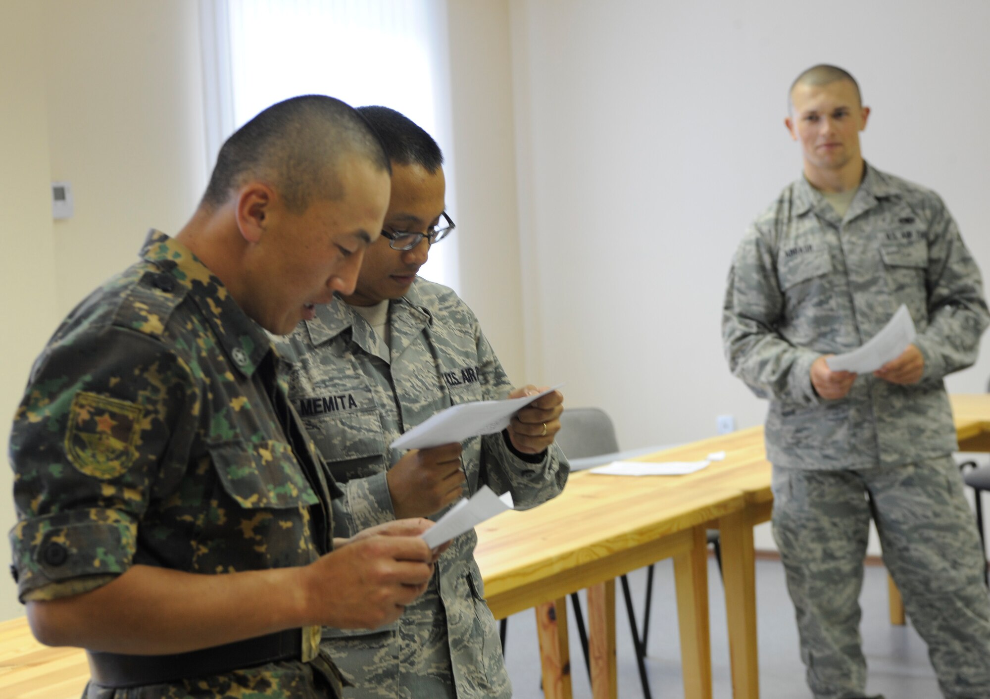 Staff Sgt. Ramon Memita (center) helps a soldier from Koi Tash, Kyrgyzstan, practice a dialogue in English during a language lab led by Senior Airman Michael Abrash (right) Aug. 11. Memita is assigned to the Theater Security Cooperation humanitarian assistance section. He is deployed to the Transit Center at Manas from Yokota Air Base, Japan. Abrash is a TSC linguist. He is deployed to the Transit Center from March Air Reserve Base, Calif. (U.S. Air Force photo/Tech. Sgt. Tammie Moore)