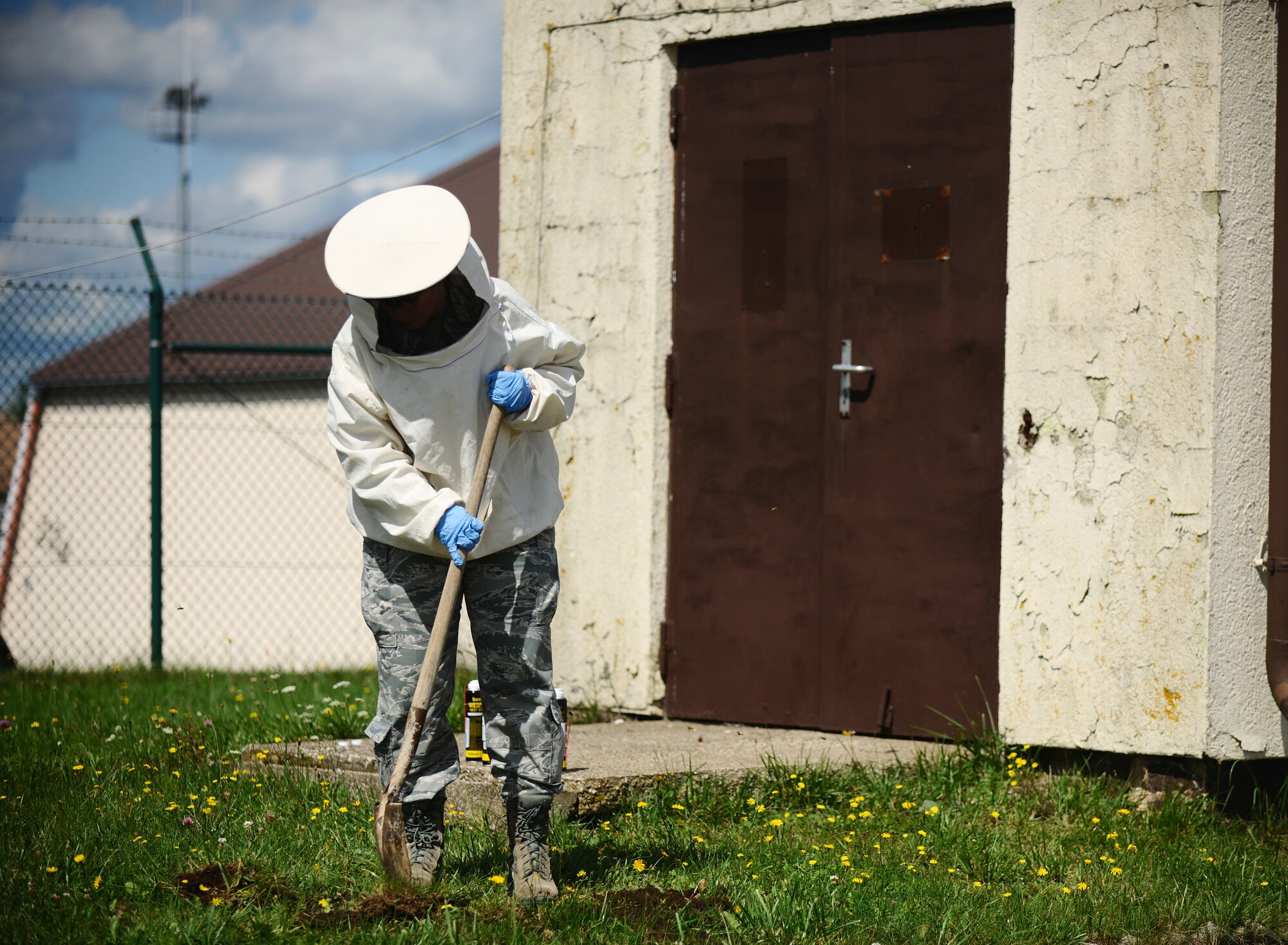 SPANGDAHLEM AIR BASE, Germany -- Airman 1st Class Elizabeth McCasland, 52nd Civil Engineer Squadron pest controller, digs up a wasp nest after spraying it with pesticide here Aug. 15. The 52nd Civil Engineer Squadron Pest Management Flight specializes in ridding the base of insects, rodents and animals that may pose harm to base members and daily mission operations. (U.S. Air Force photo/Staff Sgt. Nathanael Callon)