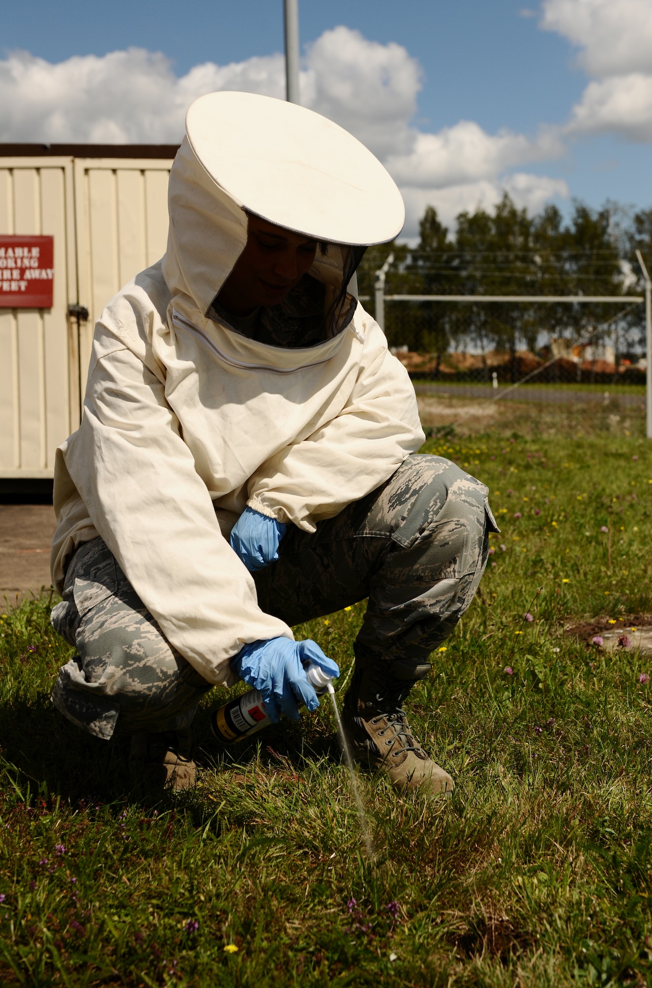 SPANGDAHLEM AIR BASE, Germany -- Airman 1st Class Elizabeth McCasland, 52nd Civil Engineer Squadron pest controller, sprays pesticide on a wasp nest in the ground here Aug. 15. The 52nd Civil Engineer Squadron Pest Management Flight specializes in ridding the base of insects, rodents and animals that may pose harm to base members and daily mission operations. (U.S. Air Force photo/Staff Sgt. Nathanael Callon)