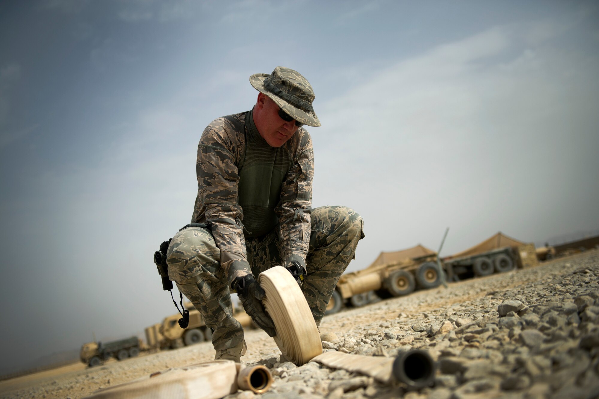 Tech. Sgt. Gabriel Johnson, deputy fire chief, reels up a fire hose Aug. 14, 2011 at Forward Operating Base Apache in Qalat, Afghanistan.  Johnson is part of the crash, fire and rescue team. (U.S. Air Force photo by Staff Sgt. David Salanitri)