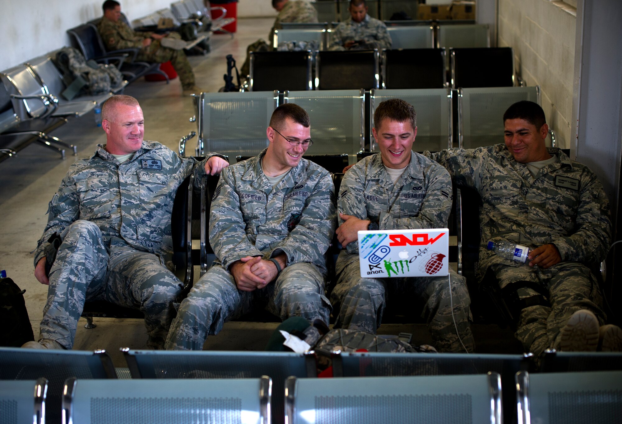 Firefighters with a quick strike team share in laughs as they watch a TV show in the Kandahar, Afghanistan passenger terminal, August 11, 2011. The firefighters are part of a team, deployed to set up crass, fire and rescue at a bare base. (U.S. Air Force photo by Staff Sgt. David Salanitri/Released)