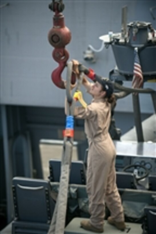 Petty Officer 3rd Class Miranda DaRae, assigned to the amphibious transport dock ship USS New Orleans (LPD 18), hooks a cable to a crane while unloading a rigid-hull inflatable boat before a practice mission with the 11th Marine Expeditionary Unit Maritime Raid Force while underway in the Pacific Ocean on Aug. 12, 2011.  The New Orleans and embarked Marines are conducting pre-deployment work-ups as part of the Makin Island Amphibious Ready Group.  
