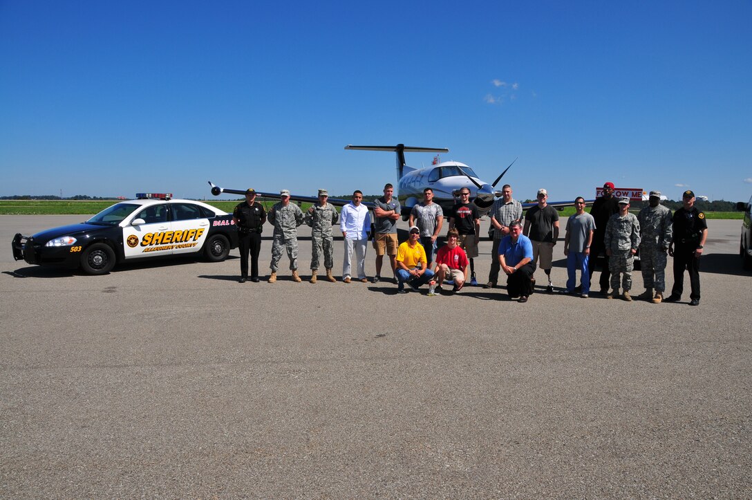Wounded warriors from Walter Reed National Military Medical Center at Bethesda and Ft. Belvior Community Hospital, stand next to 128 BSB Pennsylvania National Guard troops, volunteer pilots, and Allegany Sheriff deputies after deplaning in Pittsburgh for their two day trip in the city.