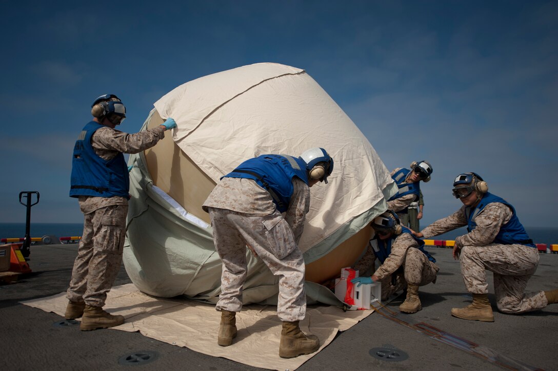 Marines serving with the 11th Marine Expeditionary Unit's command element aboard the amphibious assault ship Makin Island prepare to launch a communications balloon Aug. 16. The balloon is designed to carry a radio-relay system up to 80,000 feet above Earth, extending communications to an area 600 miles in diameter, regardless of terrain. The launch from sea signaled the unit's and the ship's first of a device of its kind.
