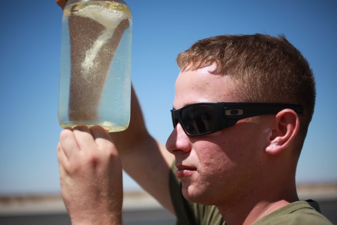 Bulk fuel specialist Lance Cpl. Michael B. McGuiness inspects a fuel sample here Aug. 16 at a desert arming-and-refueling point where Marines serving with Marine Medium Helicopter Squadron 268 (Reinforced) refueled helicopters carrying riflemen from an oceangoing ship 200 miles away, allowing a heliborne raid company to press on to its nighttime training objective miles away. Marines serving with the 11th Marine Expeditionary Unit’s reinforced helicopter squadron set up and manned the position – operating at night and filling seven helicopters. McGuiness, 20, is from Cromwell, Conn.