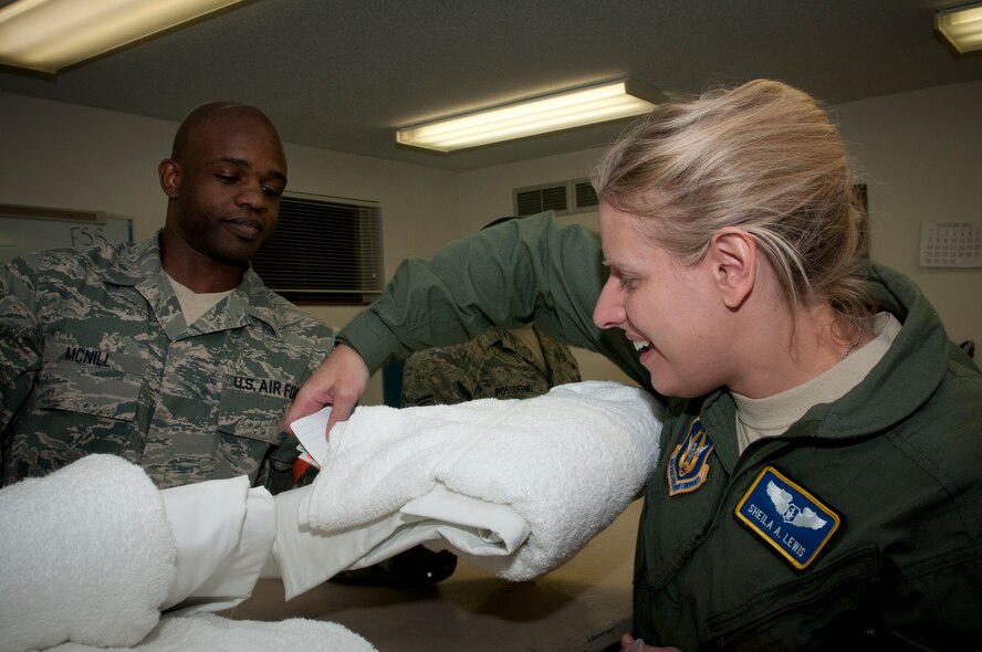 VOLK FIELD. Wis. -- Senior Airman Leonard McNill, 459th Services Flight, Joint Base Andrews, Md., provides linens to Maj. Shelia Lewis, 459th Aeromedical Evacuation Squadron, during an  Operational Readiness Training Program here Aug. 16. During the ORTP, the 459 ARW learned additional skills and practiced techniques preparing the Reserve Airmen for both real-world rapid deployment scenarios and an upcoming Operational Readiness Inspection in 2012. (U.S. Air Force Photo/Tech. Sgt. Steve Lewis) 