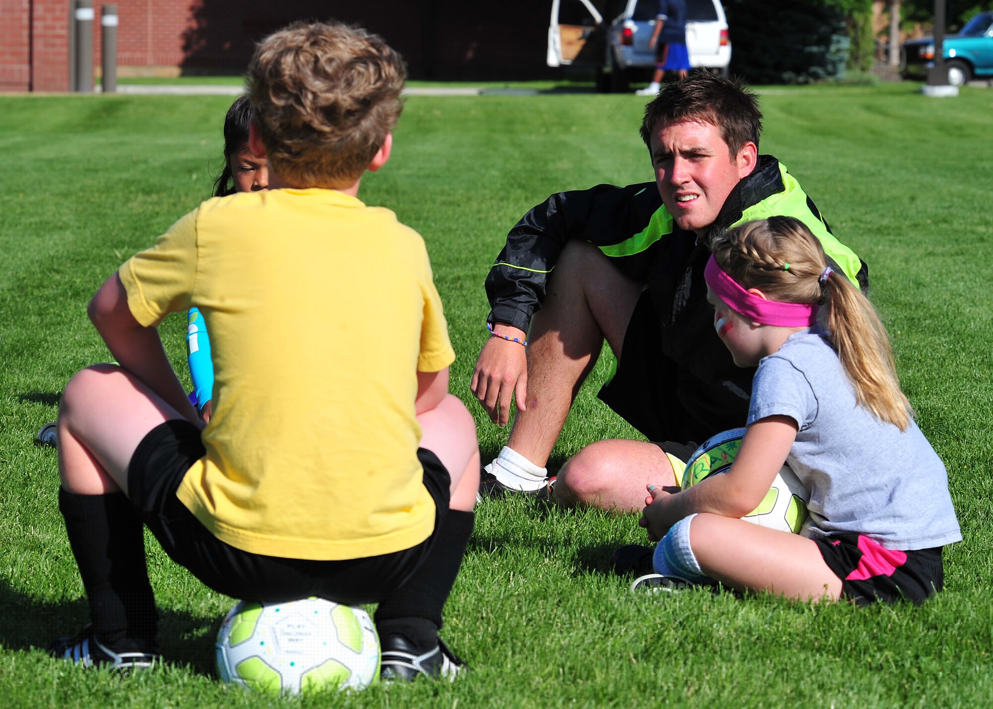 O’Brien takes a moment to get to know the kids before they start their soccer session Aug. 10. (U.S. Air Force photos/Staff Sgt. Michael Means)