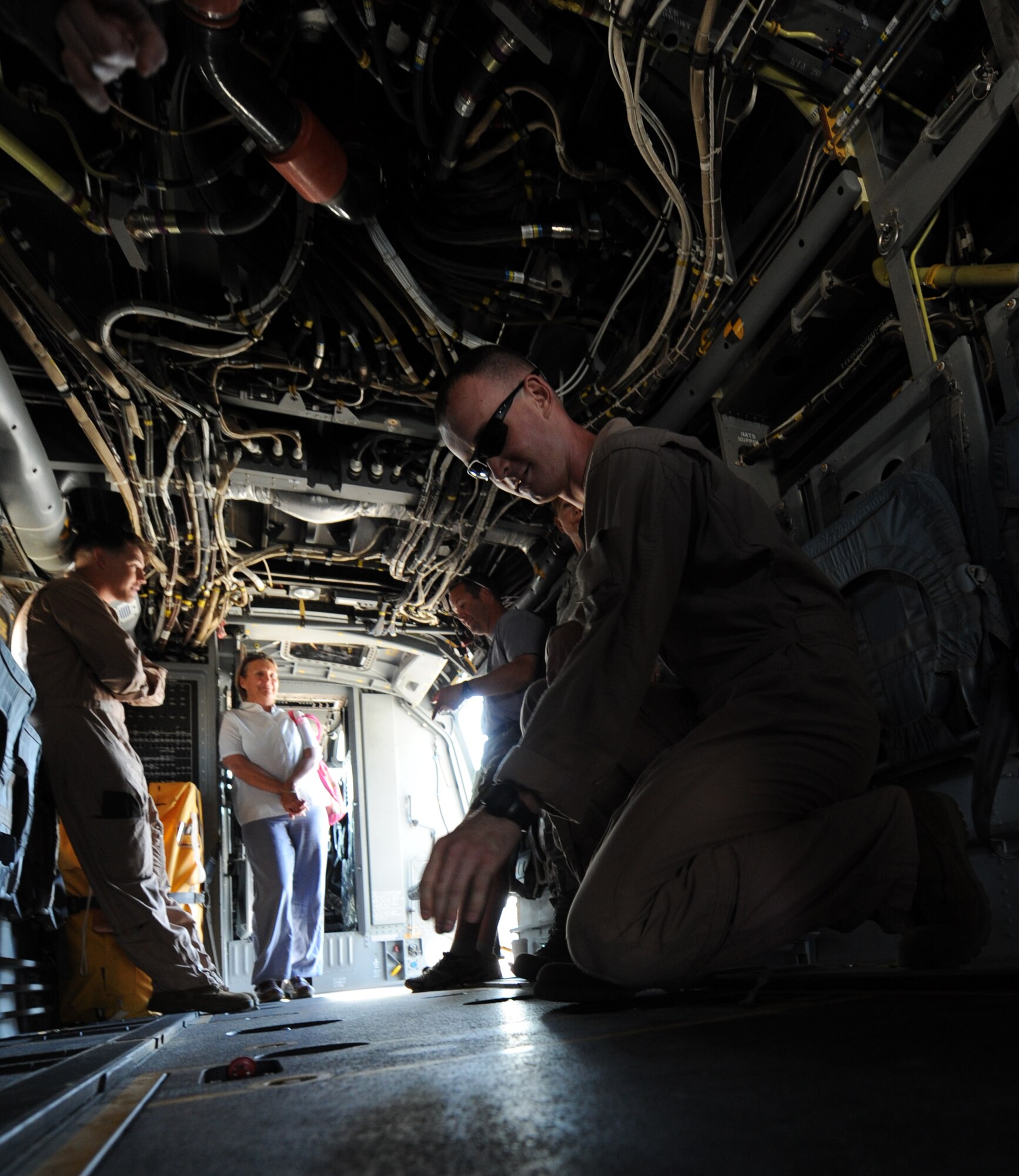 U.S. Marine Corps Sgt. Christopher Miller, a MV-22 Osprey crew chief assigned to Marine Medium Tiltrotor Squadron 166 out of Marine Corps Air Station Miramar, Calif., kneels to open a hatch during a tour of the inside of a VM-22 Osprey aircraft at Mountain Home Air Force Base, Idaho, Aug. 17, 2011. The MV-22 Osprey aircraft travels at two-and-a-half times the speed of current helicopters, cruises at 13,000 feet and has the capability to quickly get into and out of landing zones. (U.S. Air Force photo by Senior Airman Debbie Lockhart)