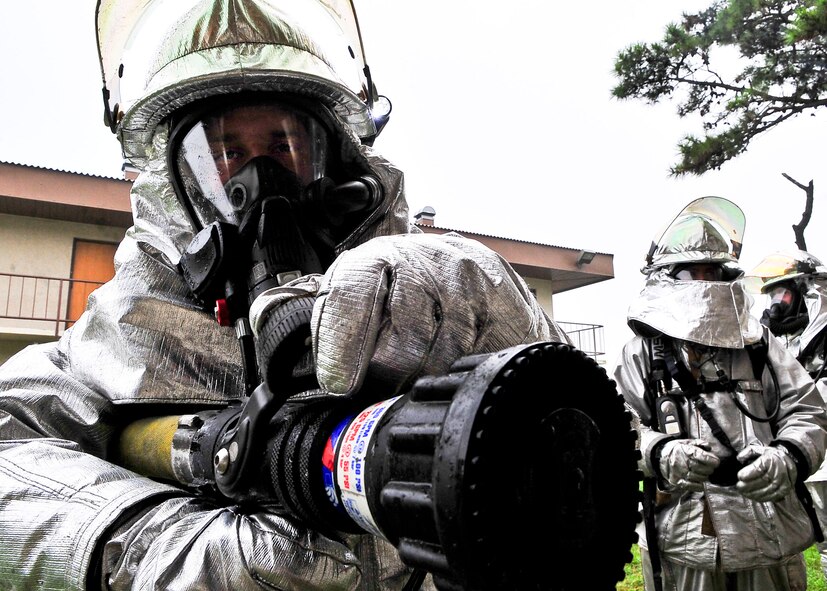 A member of the 51st Fighter Wing Civil Engineer Squadron firefighter, prepares to enter an abandoned dorm to extinguish a structural fire during Silver Flag, Aug. 16. During Silver Flag members of the 51st Fighter Wing Civil Engineer Squadron, completed JS-List structural fire training where they extinguished fires and conducted hydraulic ventilation. (U.S. Air Force Photo by/ Senior Airman Adam Grant)