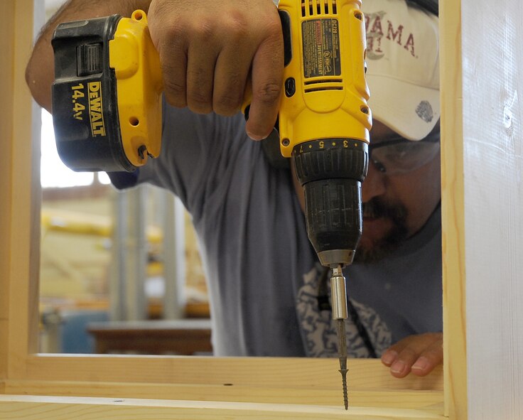 Retired Senior Master Sgt. Mahmoud Rasouliyan tightens a screw with a power drill at the woodshop in the Arts and Crafts Center on Barksdale Air Force Base, La., Aug. 17. The woodshop offers a class once a month, which includes eight hours of instruction on safety, equipment and the materials needed to build, sand and stain a bookshelf.  (U.S. Air Force Photo/2nd Lt. Tori Lalich)(RELEASED) 