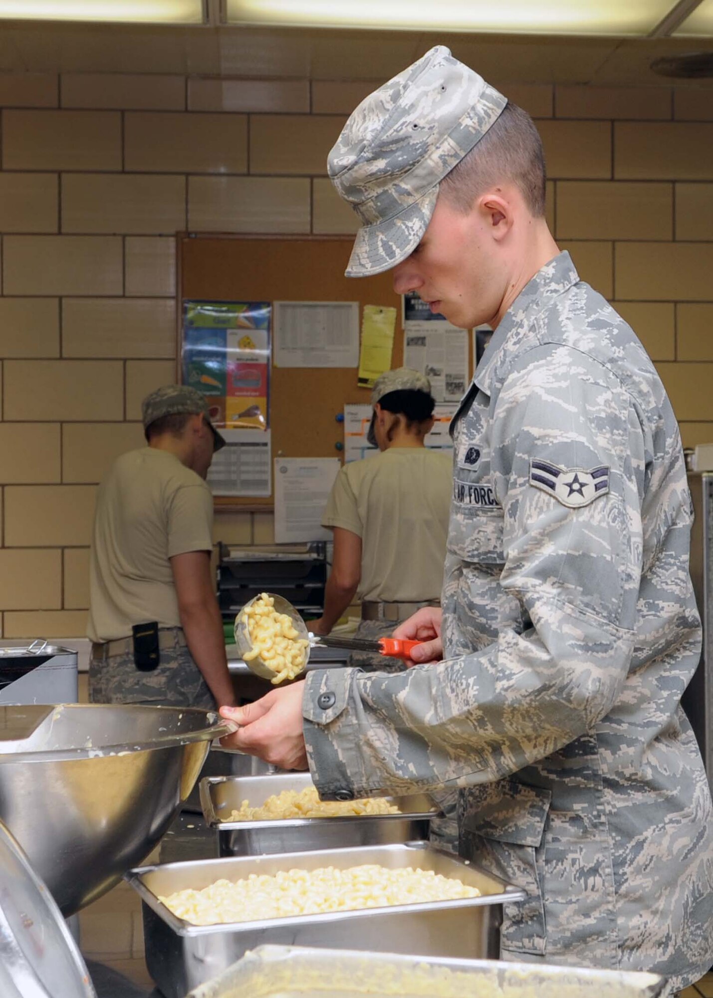 ALTUS AIR FORCE BASE, Okla.—Airman 1st Class Shawn Hanser, 97th Force Support Squadron food service specialist, prepares macaroni and cheese for lunch at the Solar Inn Dining Facility, Aug. 12, 2011. The facility serves four meals daily and offers carry-out service Monday through Friday. (U.S. Air Force photo by Senior Airman Leandra D. Stepp / 97th Air Mobility Wing / Public Affairs / Released)