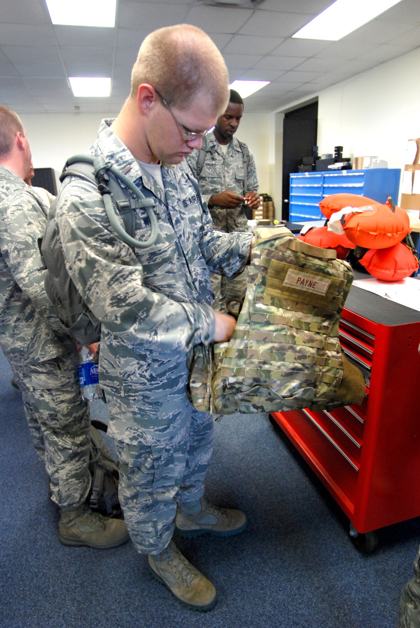 PATRICK AIR FORCE BASE, Fla.- 2nd Lt. Joshua Woods, chaplain candidate, feels the weight of an Eagle Rhodesian Recon Vest, used by HH-60G Pave Hawk helicopter crew members. The chaplain candidates are part of the Air Force Chaplains Candidate Intensive Intership Program touring the base to get a better understanding of the 920th Rescue Wing combat-search-and-rescue mission. (U.S. Air Force photo/Airman 1st Class Natasha Dowridge)