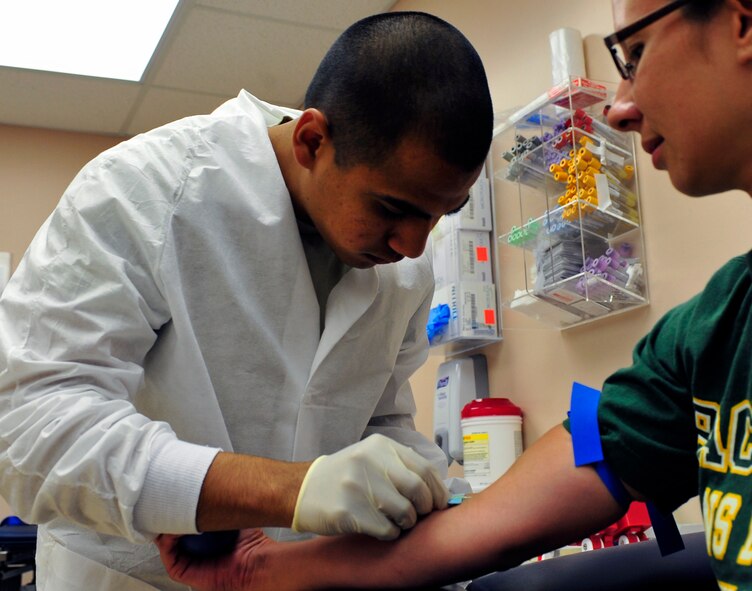 U.S. Air Force Airman 1st Class Marco Cruz, 20th Medical Support Squadron medical laboratory technician, draws blood from Teresa Prier, wife of Army Maj. Richard Prier, Third Army/Army Central, at the base hospital at Shaw Air Force Base, S.C. on Aug. 17, 2011. Cruz is the Warrior of the Week for the week of August 15 through 19. (U.S. Air Force photo/Airman1st Class Daniel Phelps/Released)