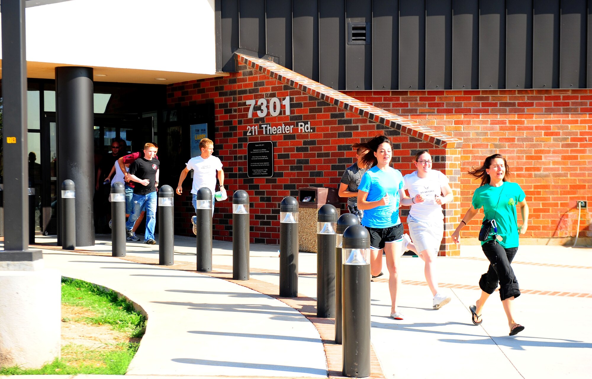 Dyess personnel evacuate the base theater during an Emergency Management Exercise Aug. 17, 2011 at Dyess Air Force Base, Texas. Dyess conducts large-scale exercises with local agencies every two to three years to keep inter-agency operability at a high and maintain a strong working relationship. (U.S. Air Force photo by Senior Airman Chelsea Browning/ Released)