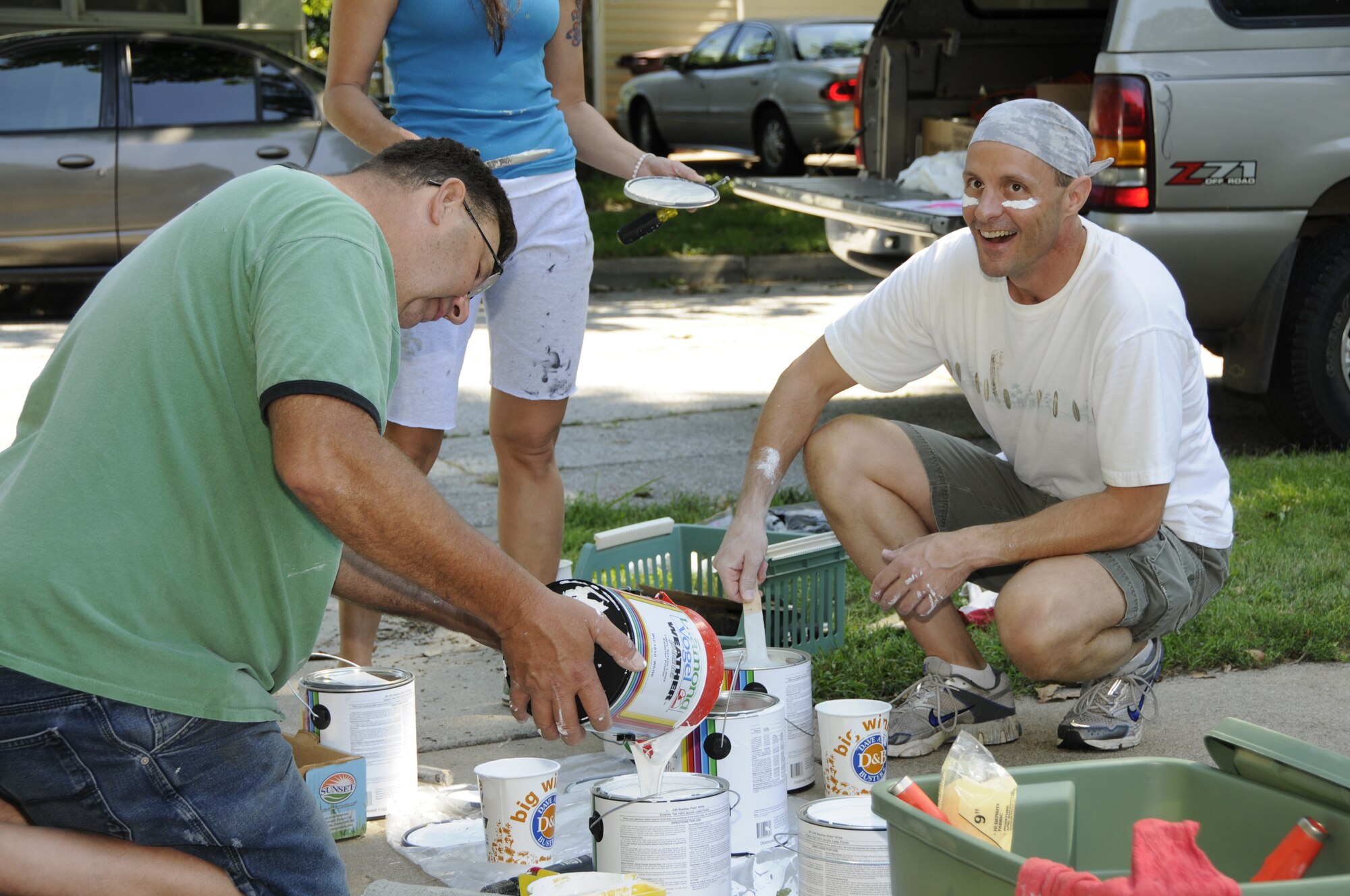 Chief Master Sgt. Douglas E. Schulz and Senior Master Sgt. Stuart P. Stofferahn pour and stir the paint used during the Lincoln Paint-a-thon in Lincoln, Neb. on Aug. 13, 2011. Schulz and Stofferahn coordinated the event and recruited volunteers.  (Nebraska Air National Guard photo by Master Sergeant Vern Moore) (Released)