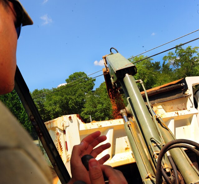 U.S. Air Force Senior Airman Steve Williams, 20th Civil Engineer Squadron heavy equipment operator, offloads clay from the ground section of pipes in need of repair at Shaw Air Force Base, S.C., August 16, 2011. The Rhodes Water Tower next to Highway 441 remains the backup water reservoir for Shaw's main water tower near the enlisted dormitories. After repairs are completed, a water sample will be taken to test the levels of purity, phosphates, acidity and alcoholicity to ensure a fresh water supply is available.  (U.S. Air Force photo/Airman 1st Class Neil D. Warner)(Released)