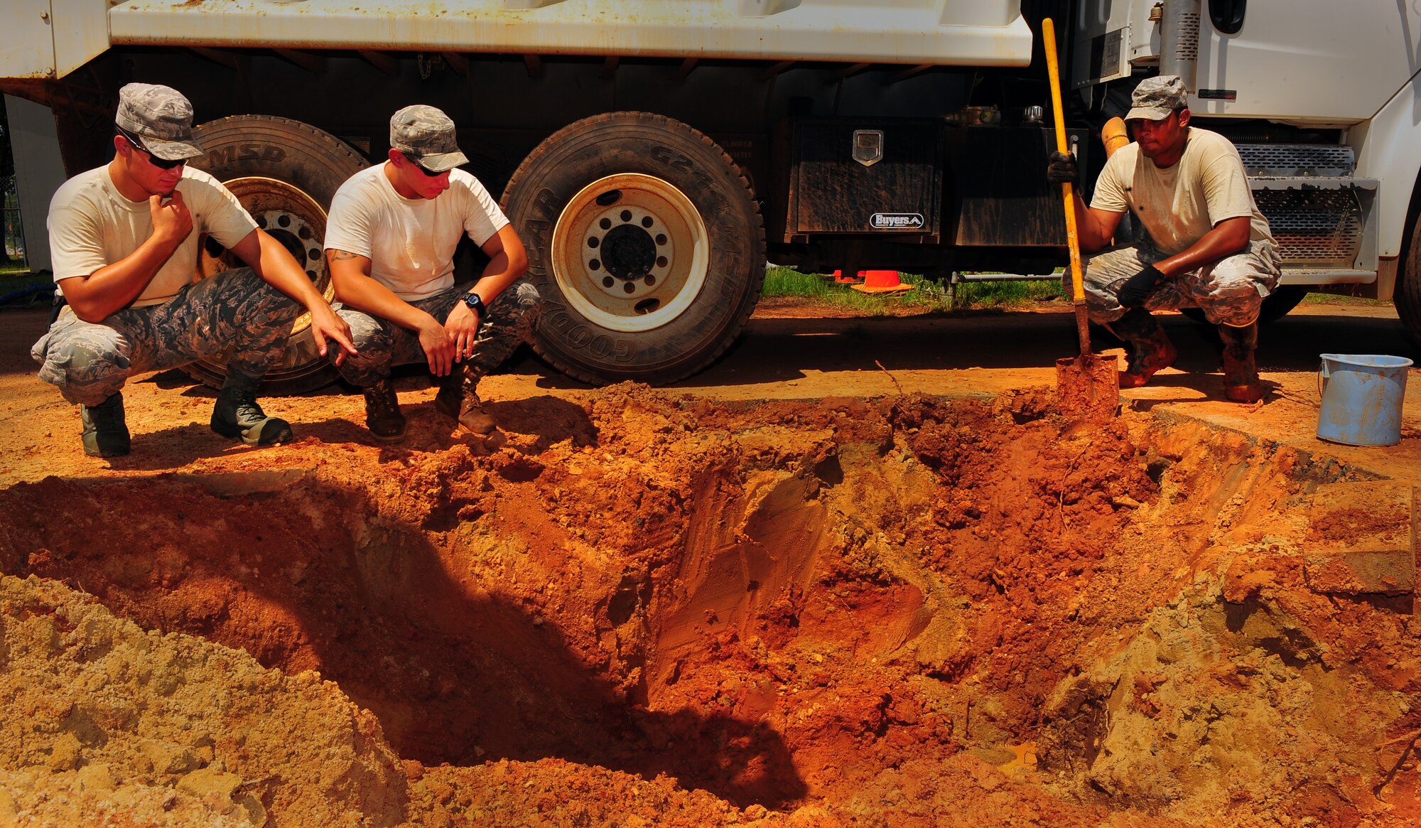 U.S. Air Force Senior Airman Steve Williams, Senior Airman Brian King, 20th Civil Engineer Squadron heavy equipment operators, and Senior Airman Kason Kearns, 20th CES water and fuels maintainer, discuss a plan to handle the leaking pipes at Shaw Air Force Base, S.C., Aug. 16, 2011. The Rhodes Water Tower next to Highway 441 remains the backup water reservoir for Shaw's main water tower near the enlisted dormitories. After repairs are completed, a water sample will be taken to test the levels of purity, phosphates, acidity and alcoholicity to ensure a fresh water supply is available.  (U.S. Air Force photo/Airman 1st Class Neil D. Warner)(Released)
