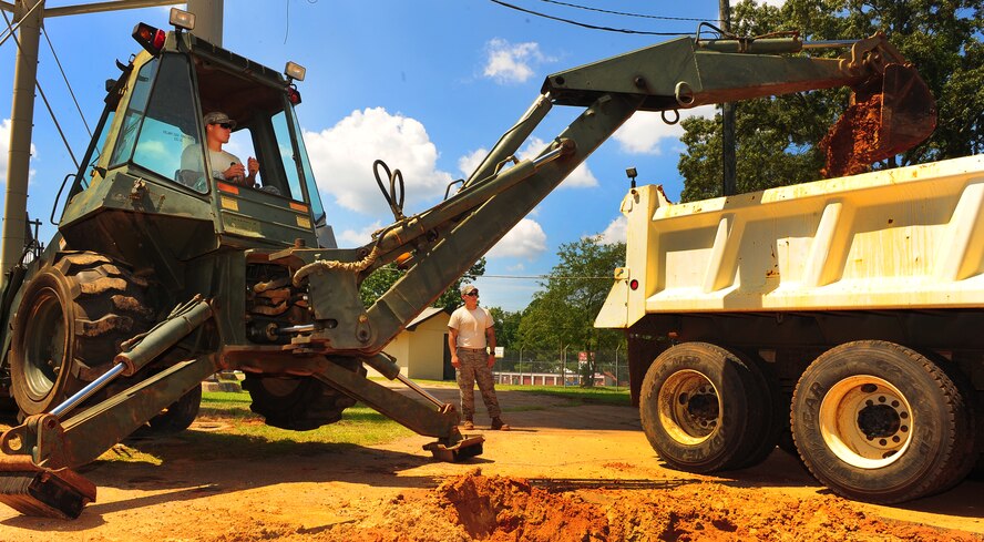 U.S. Air Force Senior Airman Steve Williams and Senior Airman Brian King, 20th Civil Engineer Squadron heavy equipment operators, coordinate to offload clay removed from the dig site into a dump truck at Shaw Air Force Base, S.C., Aug. 16, 2011. The Rhodes Water Tower next to Highway 441 remains the backup water reservoir for Shaw's main water tower near the enlisted dormitories. After repairs are completed, a water sample will be taken to test the levels of purity, phosphates, acidity and alcoholicity to ensure a fresh water supply is available.  (U.S. Air Force photo/Airman 1st Class Neil D. Warner)(Released)