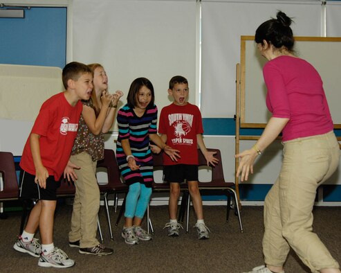 HANSCOM AIR FORCE BASE, Mass. - Alex Baumann, Andie Light, Hope Ensminger and Carter Baumann (left to right) practice different acting techniques with Lucy Braid on Aug. 16 at the Hanscom Primary School in order to prepare for the Missoula Children’s Theater production of Robin Hood. The children practiced throughout the week. The play will take place at the school Aug. 20 at 10 a.m. and 2 p.m. Admission will be free. (U.S. Air Force photo by Linda LaBonte Britt)