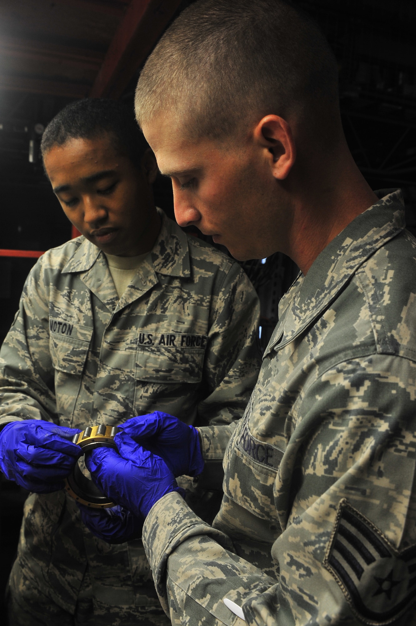 U.S. Air Force Airman 1st Class Julyon Moton and Staff Sgt. James Maxwell,
20 Civil Engineer Squadron electrical power production, inspect a
burrier-arresting kit-12 roller assembly at Shaw Air Force Base S.C., Aug.
17, 2011. The electrical power production's job is making sure the base generators are up and running. (U.S. Air Force photo by Airman 1st Class Ashley Gardner/ Released)