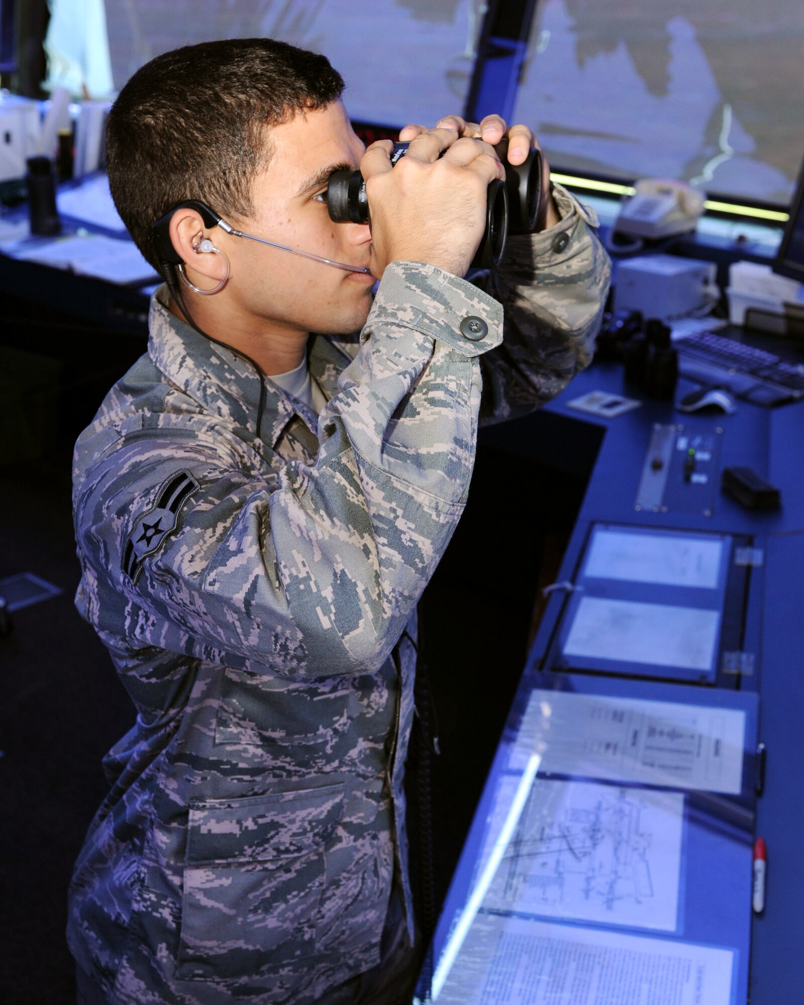 U.S. Air Force Airman 1st Class Joseph Thomas, 20th Operation Support Squadron air traffic controller, looks through a pair of binoculars in the Air Traffic control tower, Shaw Air Force Base, S.C., Aug. 16, 2011. James and Joseph Thomas are identical twins, who have been stationed at Shaw AFB together for about 8 months.