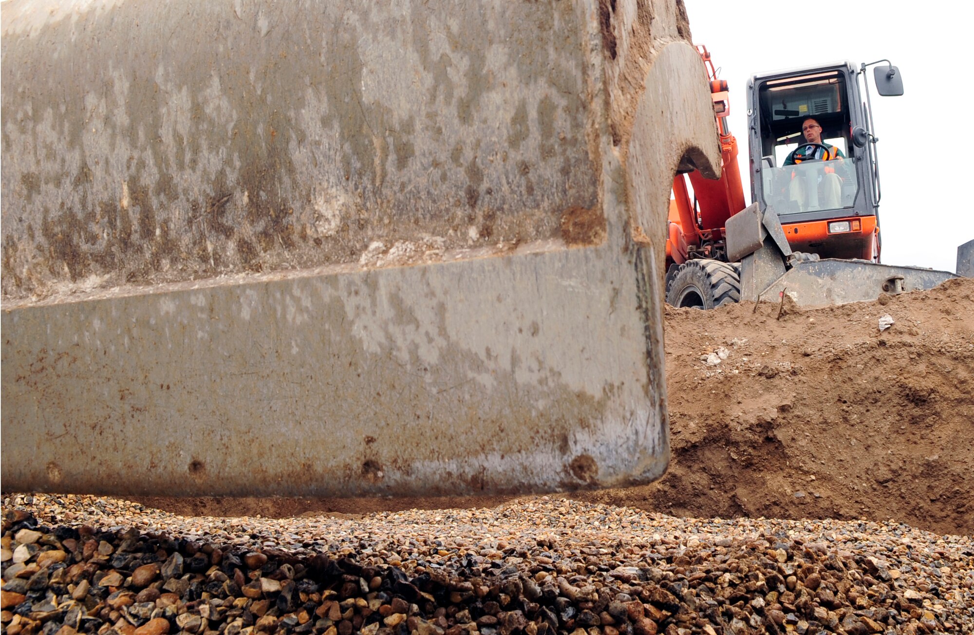 RAF MILDENHALL, England – Joe Brown, a local contractor, uses a 14-ton “rubber duck” to spread out gravel on top of a cellular soakaway drainage system as part of the Lincoln Road construction here Aug. 17, 2011. Along with a new drainage system, there will be new road crossings, foot paths, agricultural fencing and public seating added to the local area. (U.S. Air Force photo/Senior Airman Ethan Morgan)
