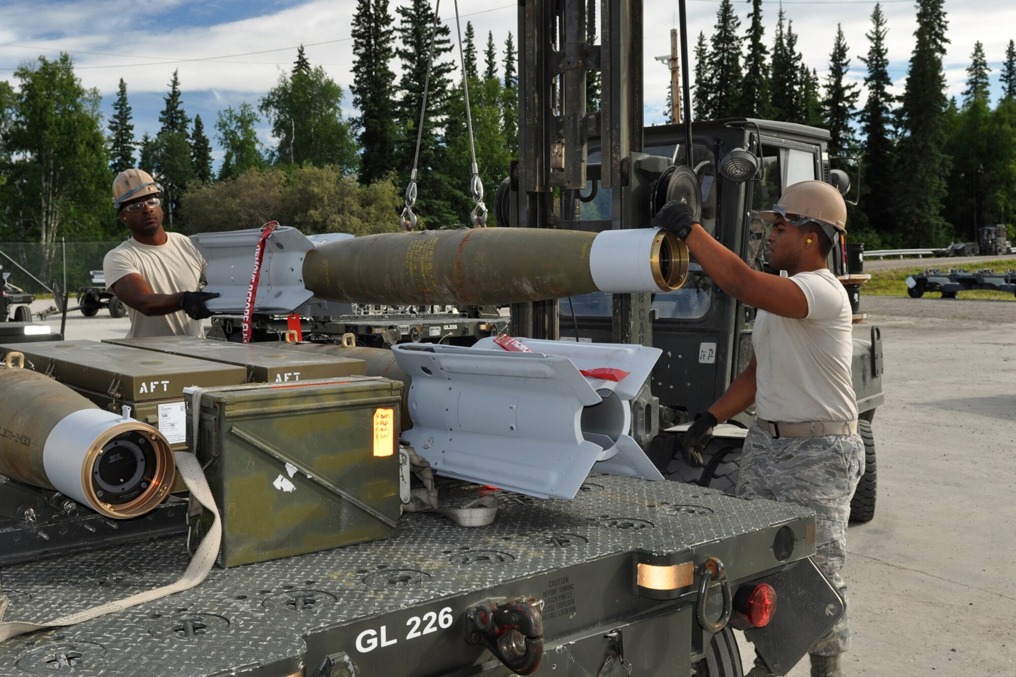 Senior Airman Terrance Woodard and Airman 1st Class Dante Thornton load a Guided Bomb Unit 12 onto a trailer for transport to the flight line at Eielson Air Force Base, Alaska, where they were deployed for training in August 2011. They are assigned to the 917th Fighter Group at Barksdale Air Force Base, La. Approximately 100 members of the 917th FG deployed to Alaska to prepare for an upcoming Air and Space Expeditionary rotation. (U.S. Air Force Photo/Senior Master Sgt. Jessica D'Aurizio)