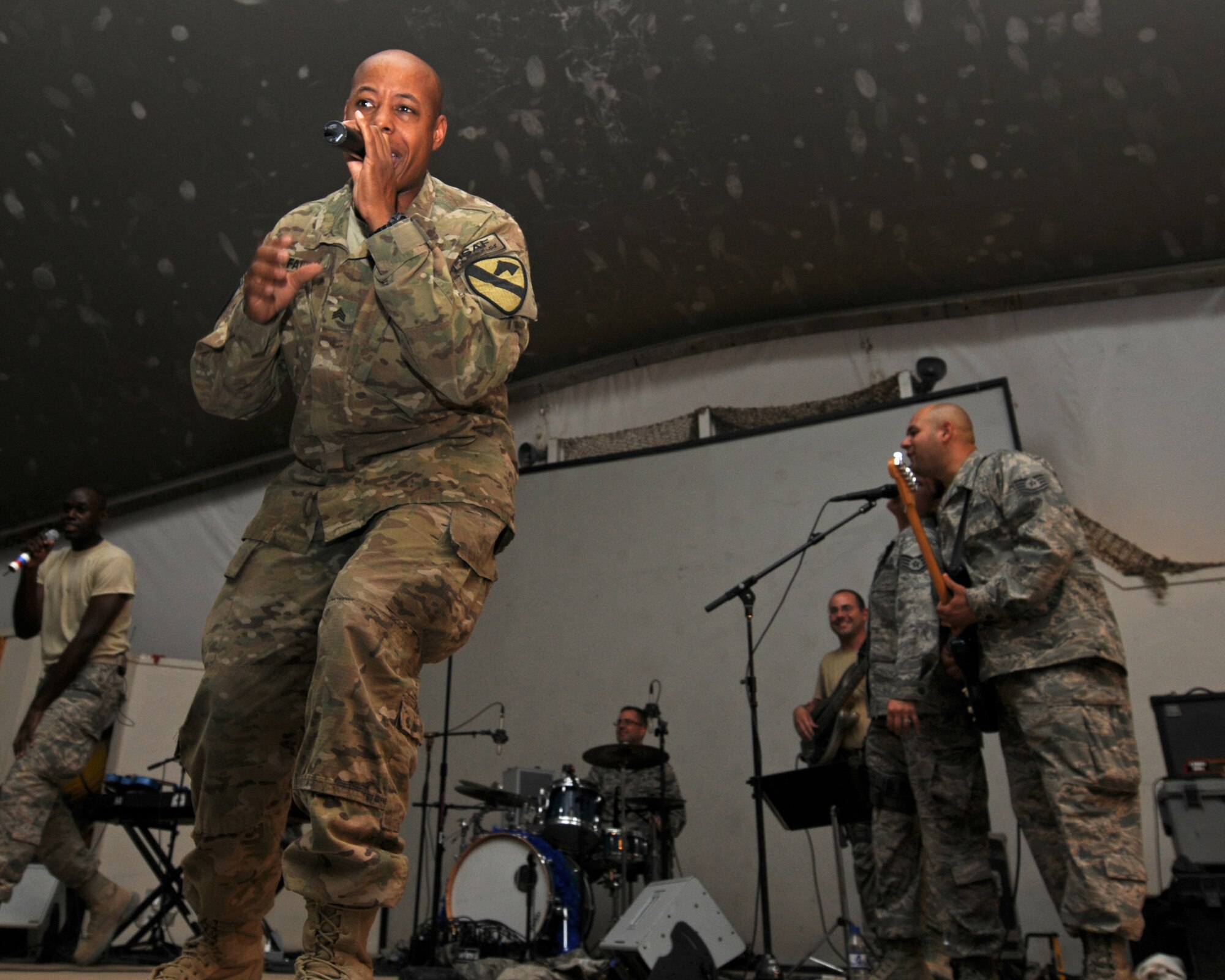 BAGRAM AIRFIELD, Afghanistan -- A U.S. Army soldier joins U.S. Air Forces Central Expeditionary Band Sidewinder during a performance at the Morale, Welfare and Recreation Clamshell here Aug. 13, 2011. The band played multiple shows each day to allow as many people as possible to attend the events. Its mission is to positively promote troop morale, diplomacy and outreach to host nation communities. (U.S. Air Force photo/Senior Airman Krista Rose) 
