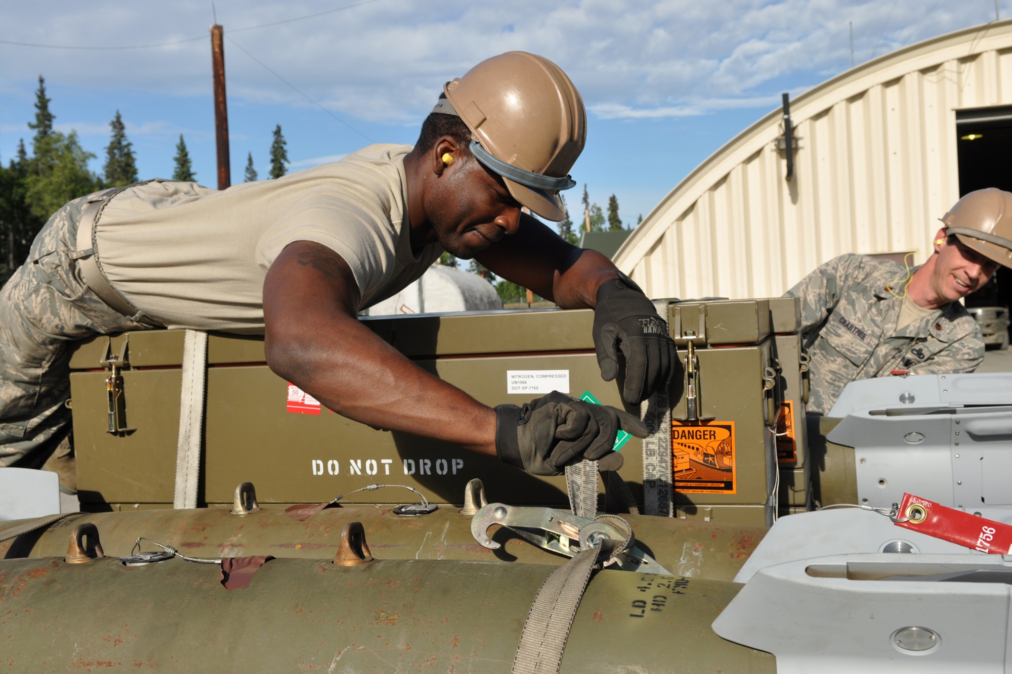 Senior Airman Terrance Woodard, an ammunition technician straps Guided Bomb Unit 12 onto a trailer for transport to the flight line at Eielson Air Force Base, Alaska while deployed for training in August 2011. Woodard is assigned to the 917th Fighter Group at Barksdale Air Force Base, La. Approximately 100 members of the 917th FG deployed to Alaska to prepare for an upcoming Air and Space Expeditionary rotation. (U.S. Air Force Photo/Senior Master Sgt. Jessica D'Aurizio)