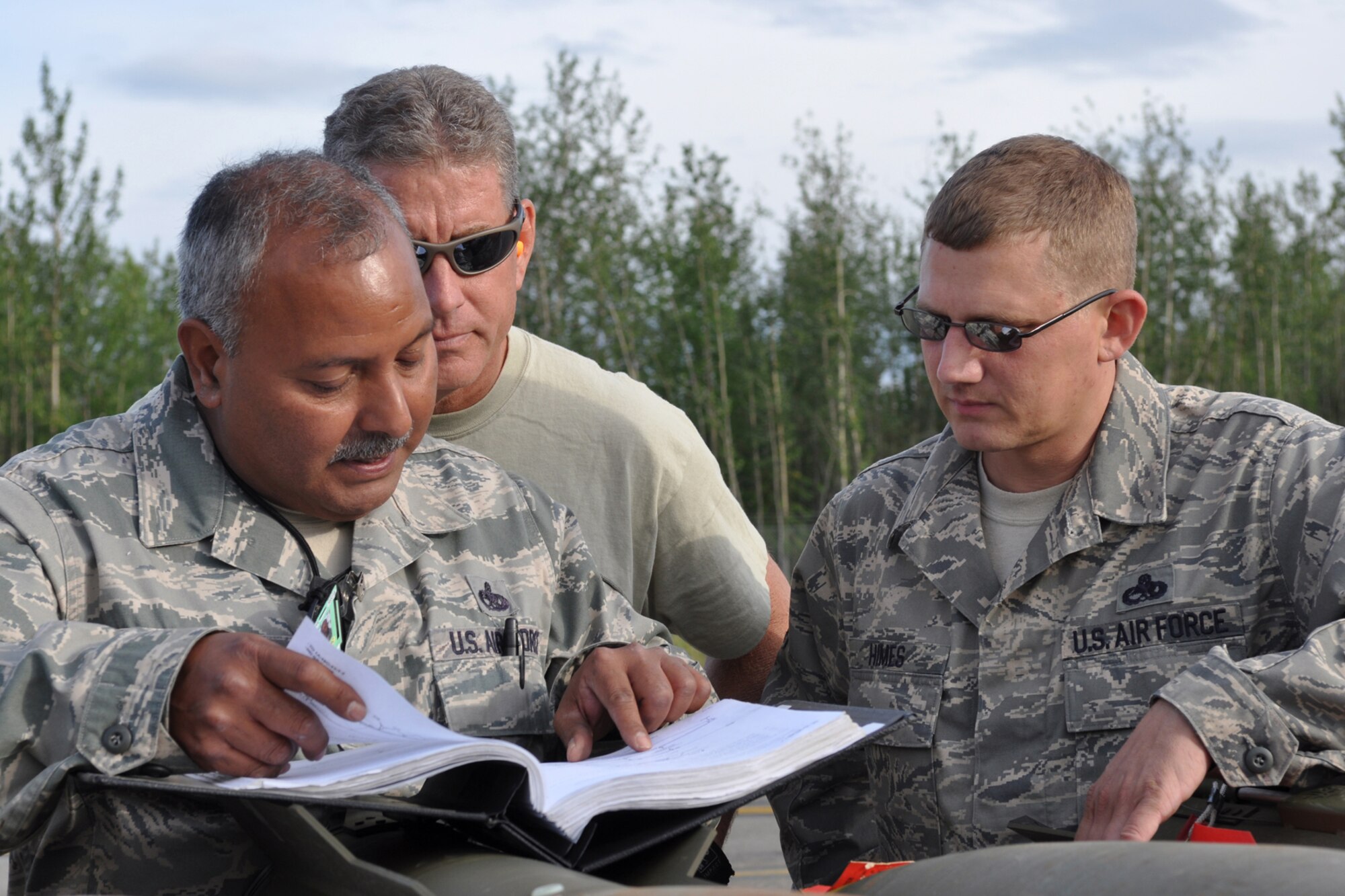 Master Sgt. Jose Limon, an A-10 Thunderbolt II weapons expeditor, Technical Sgt. Randy Sorrell, an A-10 weapons loader and Master Sgt. Matthew Himes, a munitions specialist assigned to the 917th Fighter Group, review technical data for a live load at Eielson Air Force Base, Alaska, while deployed from Barksdale Air Force Base, La., Aug. 2, 2011. Approximately 100 members of the 917th FG deployed to Alaska to prepare for an upcoming Air and Space Expeditionary rotation. (U.S. Air Force Photo/Senior Master Sgt. Jessica D'Aurizio)