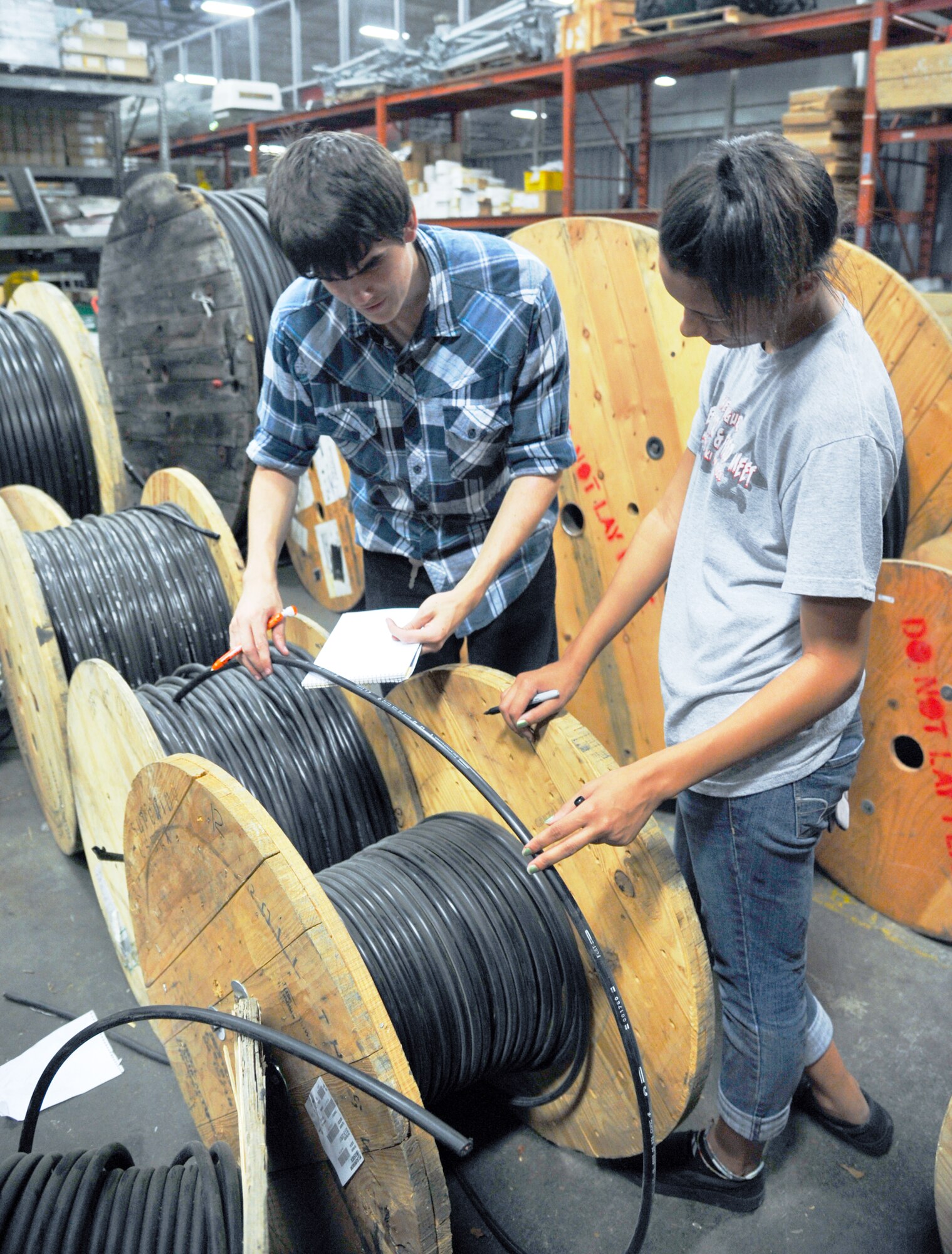 YOKOTA AIR BASE, Japan --Matt Adams (left) and Gabrielle Baker, high school students participating in the summer hire program, record the length of cables on reels, Aug. 4, 2011, at Yokota Air Base, Japan. The summer hire program is like a paid internship designed for students to work with units around the base and experience the working force. (U.S. Air Force photo/Airman 1st Class Krystal M. Garrett)
