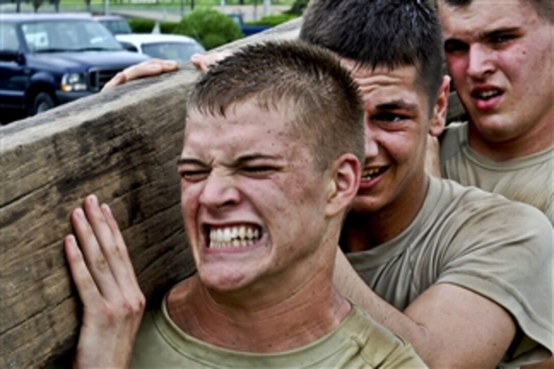 Airmen trying to qualify for the base's quick response team secure a 100-pound wooden beam on their shoulders as they complete a march at Osan Air Base, South Korea, on Aug. 9, 2011.  To become a member of the base's team airmen must overcome challenges that test their strength, endurance and ability to act as a cohesive squad.  The airmen are assigned to the 51st Security Forces Squadron.  