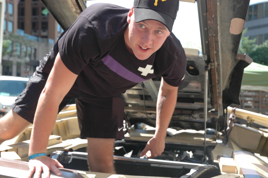 Marine Lance Cpl. Kevin Hoffman climbs into the Batmobile while on set for the new Batman movie The Dark Knight Rises, during a visit here, Aug. 17.