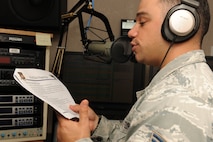 KUNSAN AIR BASE, Republic of Korea -- Staff Sgt. Michael Falvo, American Forces Network Korea operations manager, reads the “Wolf Pack Happening’s” on air here Aug. 17. AFN Kunsan provides 40 live local hours of radio every week day from 6 to 10 a.m., featuring critical command information, weather updates and morale, welfare and recreation events. (U.S. Air Force photo/Senior Airman Brittany Y. Bateman)