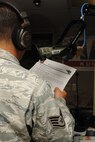 KUNSAN AIR BASE, Republic of Korea -- Staff Sgt. Michael Falvo, American Forces Network Korea operations manager, reads the “Wolf Pack Happening’s” on air here Aug. 17. AFN Kunsan provides 40 live local hours of radio every week day from 6 to 10 a.m., featuring critical command information, weather updates and morale, welfare and recreation events. (U.S. Air Force photo/Senior Airman Brittany Y. Bateman)