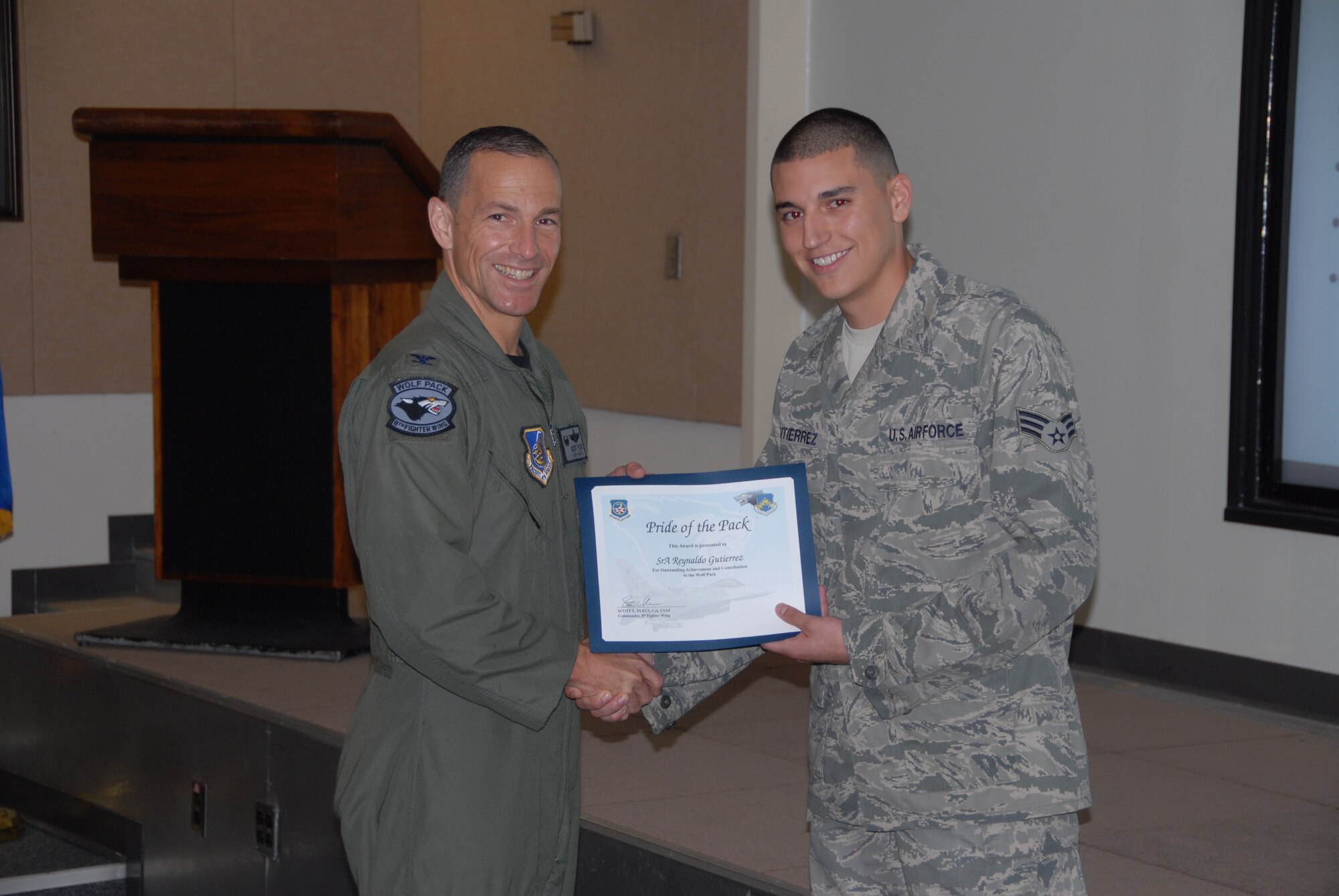 KUNSAN AIR BASE, Republic of Korea -- Col. Scott Pleus, 8th Fighter Wing commander, presents Senior Airman Reynaldo Gutierrez, 8th Logistics Readiness Squadron maintenance supply liaison, with a Pride of the Pack award here Aug. 18. (U.S. Air Force photo/Capt. Omar Villarreal)