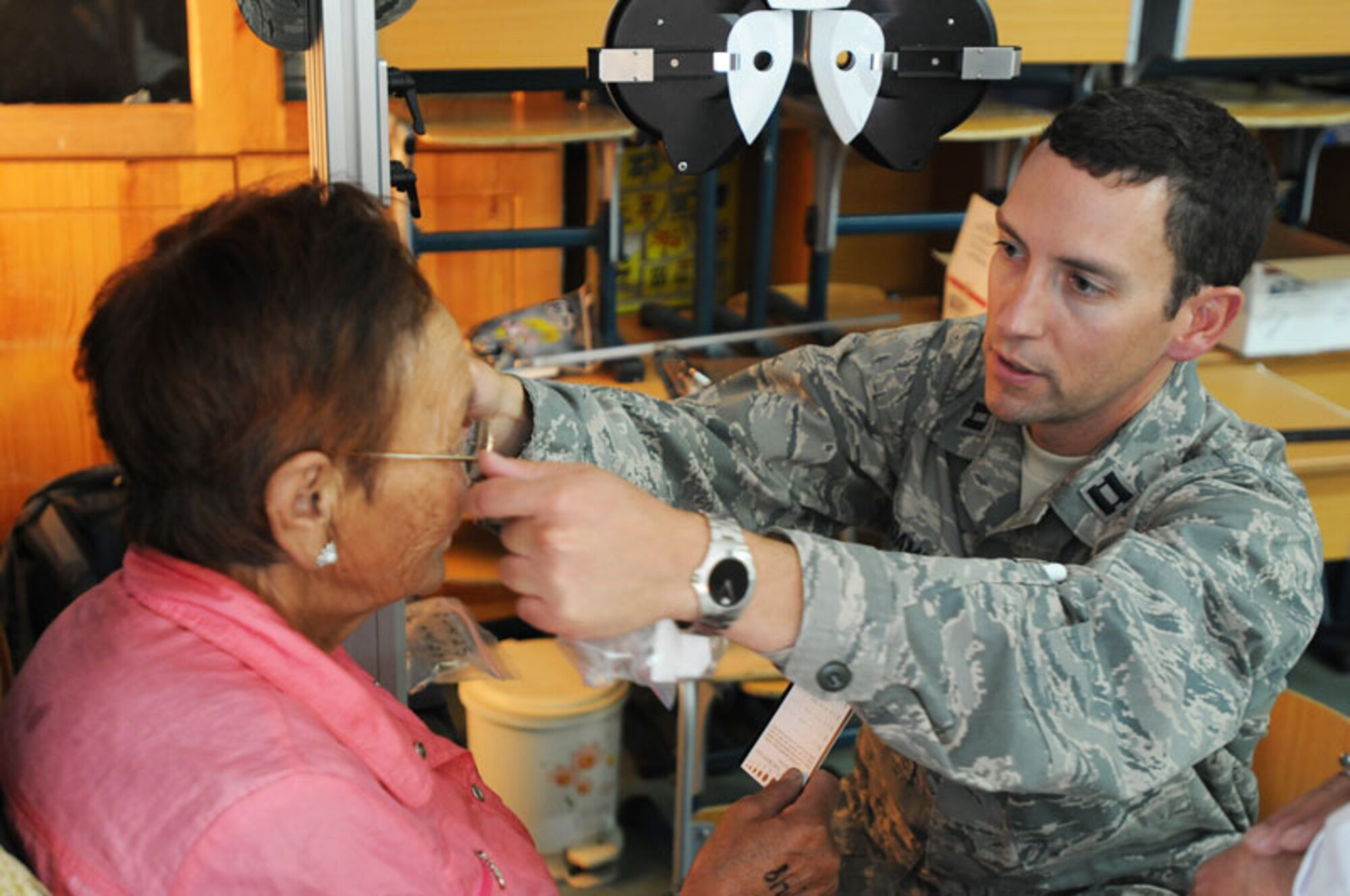 Air Force Capt. Andrew Adamich, 176th Medical Group, Alaska Air National Guard, fits a patient with a pair of glasses at a school on the outskirts of Ulaanbaatar, Mongolia. Approximately 15 Alaska National Guardsmen teamed up with multi-national forces to conduct a medical readiness training exercise as part of Khaan Quest 2011. (U.S. Army photo/Sgt. Edward Eagerton) 