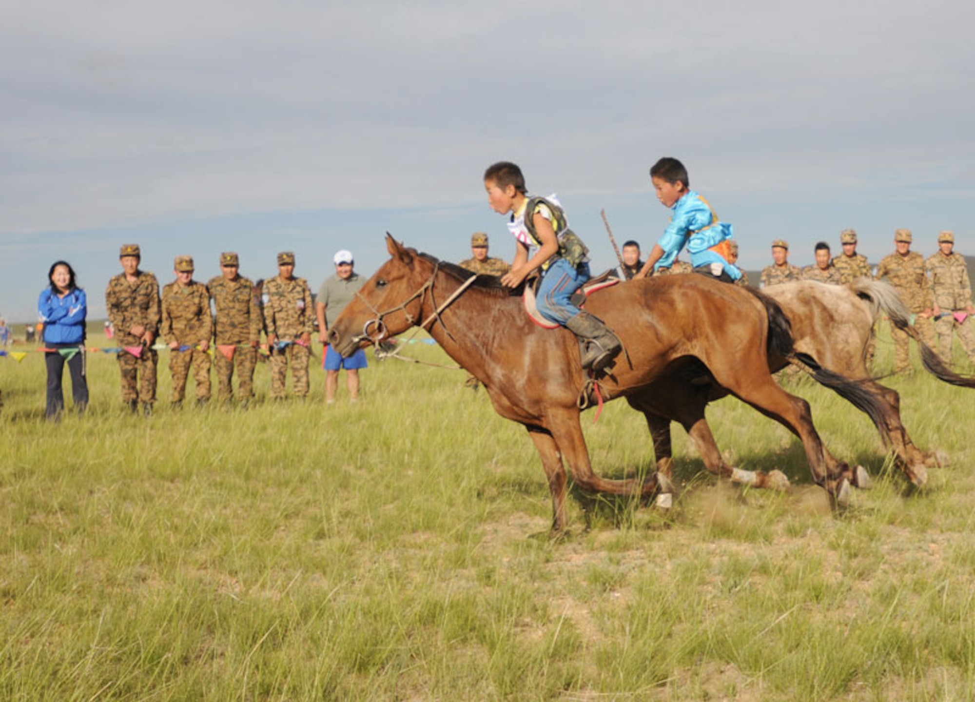 Two Mongolian children race horses during Khaan Quest’s Mongolian culture day hosted at Five Hills Training Area near Ulaanbaatar, Mongolia, Aug. 7. Horse racing, wrestling and archery, “the three games of men,” were the featured traditional sports as well as an airborne operation. (U.S. Army photo/Spc. Michelle Brown)