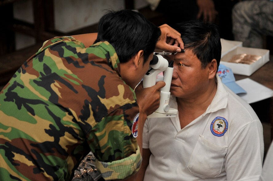 BAK KLRANG, Cambodia -- Capt. Sitha Pann uses a bio-microscope during an optometry examination here during Operation PACIFIC ANGEL 11-1 Aug.11, 2011. PA 11-1 partners U.S. and  Cambodian military and civilian personnel to provide medical, dental, optometry and engineer programs to local Cambodians as well as subject-matter expert exchanges. Captain Pann is an optometrist assigned to the Royal Cambodian Armed Forces. (U.S. Air Force photo/Staff Sgt. Christopher Boitz)