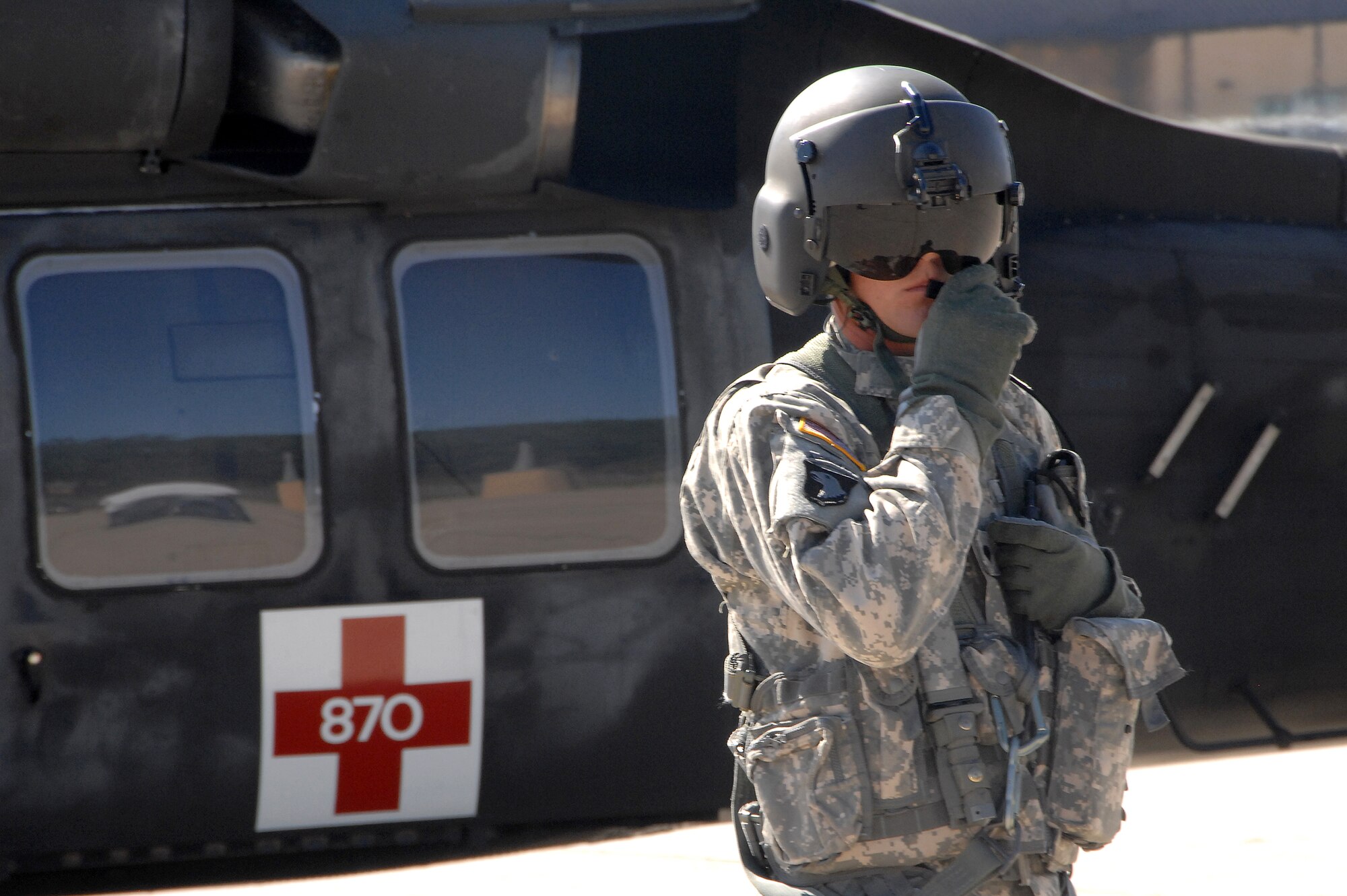 A Nebraska National Guard member communicates with the UH-60 Blackhawk helicopter pilot after landing at Offutt Air Force Base in support of the major accident response exercise Aug. 13.  The MARE is held annually to assess the readiness of emergency teams from Offutt and the surrounding community. (U.S. Air Force photo by D.P. Heard)