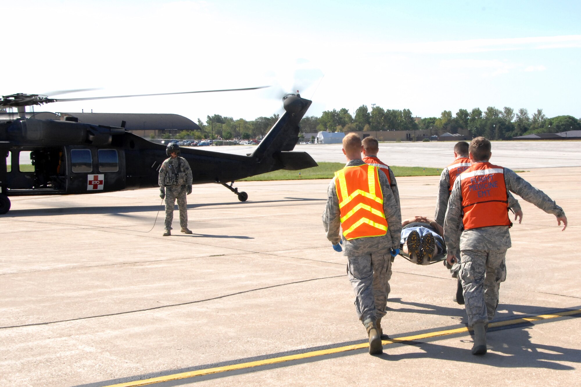 A group of Airmen carry a simulated victim to an awaiting UH-60 Blackhawk helicopter during the major accident response exercise held at Offutt Air Force Base Aug. 13. The MARE is held annually to assess the readiness of emergency teams from Offutt and the surrounding community. (U.S. Air Force photo by D.P. Heard)