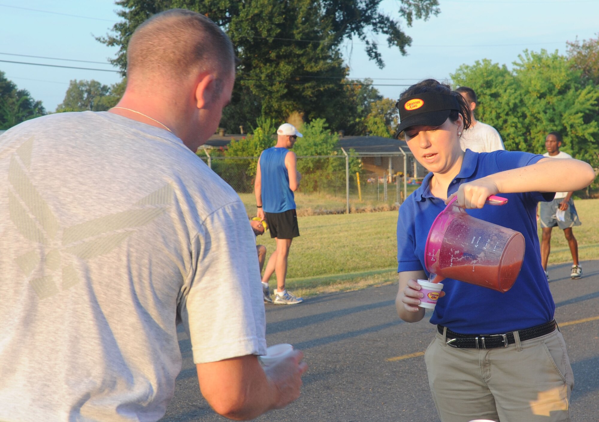Alexandra Myers, Smoothie King employee, serves a participant of the "Back to School" fun run on Barksdale Air Force Base, La., Aug. 18. The strawberry-banana smoothie contained protein for an extra boost of energy for the runners. (U.S. Air Force photo/Senior Airman Kristin High)(RELEASED)