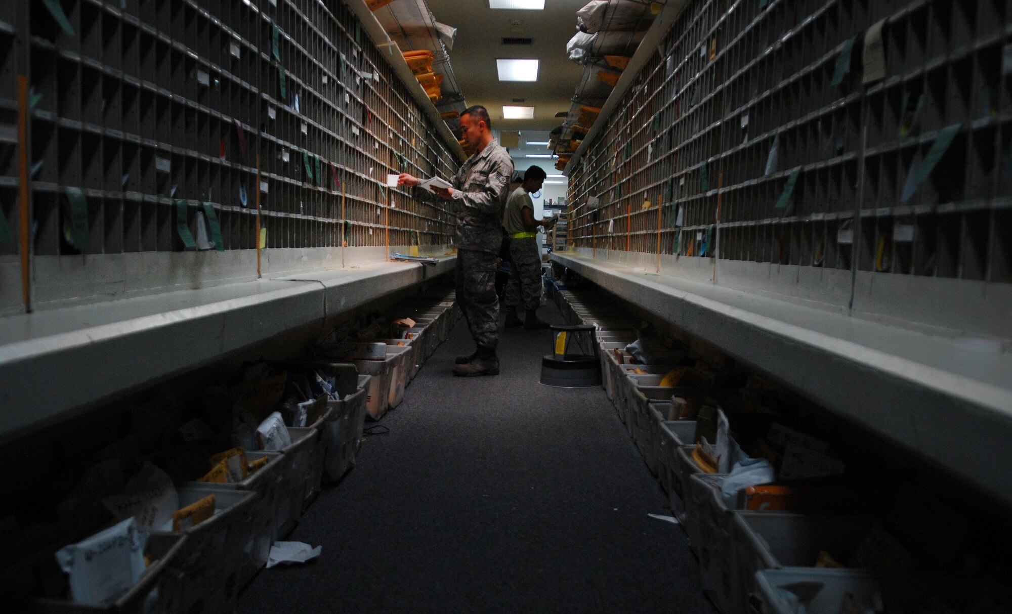 Staff Sgt. James Wong, a postal specialist with the 18th Communications Squadron, puts mail into members of Team Kadena's mail boxes at the Kadena Air Base Post Office in Japan Aug. 17.  Members of the Kadena post office have been working around the clock since Typhoon Muifa delayed thousands of pieces of mail from getting to the base. They have processed more than 3,805 pieces of Express, Letter-Class, Priority and Space Available mail totaling 83,829.5 lbs since the 60-hour typhoon.  "The active duty Airmen and local nationals of the post office strive to process and deliver mail to Team Kadena within 24 hours of receiving mail trucks," said Wong. "The post office receives two to three trucks of mail on a daily basis." (U.S. Air Force photo/Senior Airman Sara Csurilla)