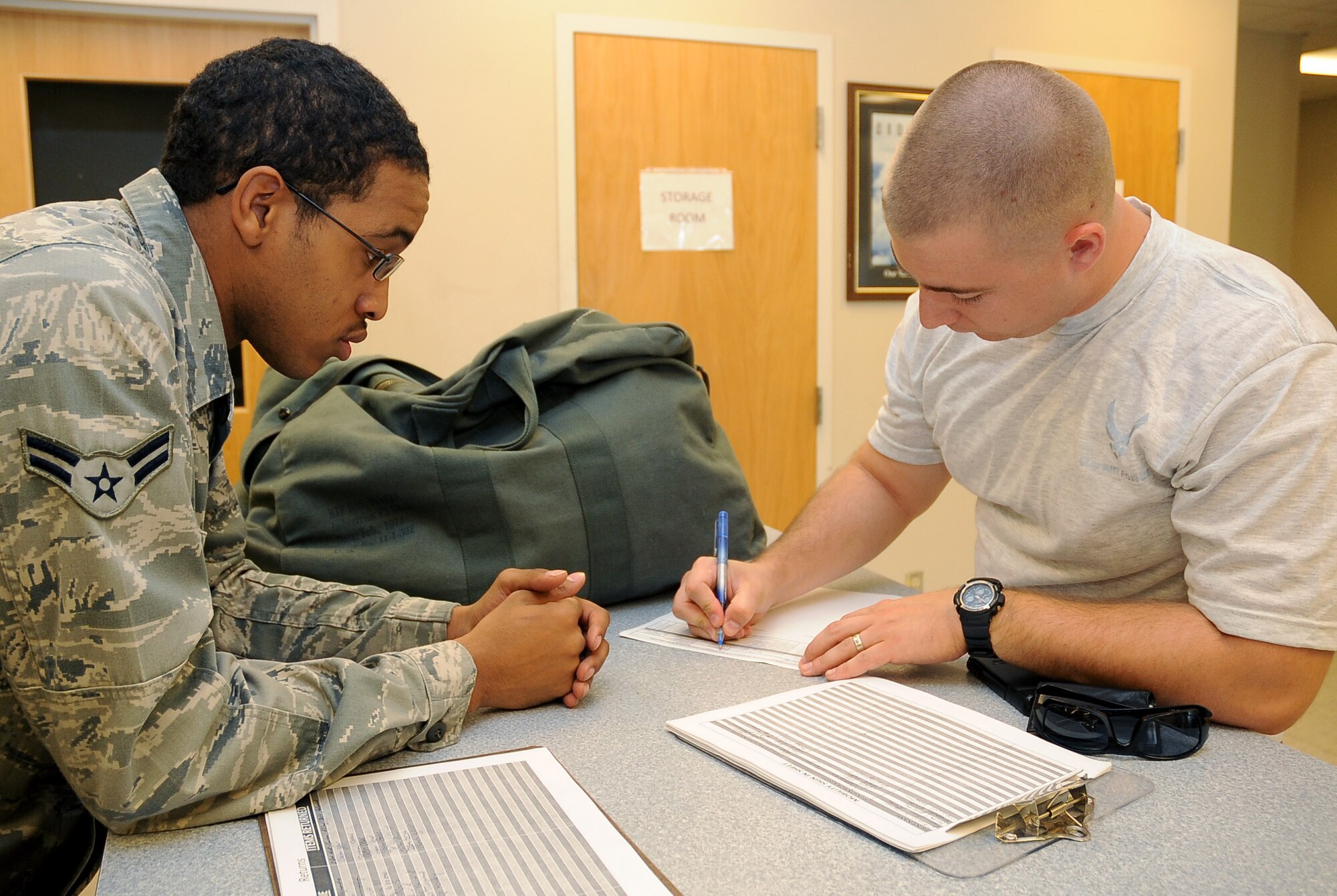 Airman 1st Class Stephen Walker (left), 2nd Logistics Readiness Squadron mobility and weapons section, watches as Staff Sgt. Eric Hill, 2nd Security Forces Squadron, signs for individual protective equipment prior to an overseas deployment on Barksdale Air Force Base, La., Aug. 17. All Airmen sign for their IPE and the hand receipts are placed into the Mobility Inventory Control Accountability System. (U.S. Air Force photo/Senior Airman Amber Ashcraft) (RELEASED)