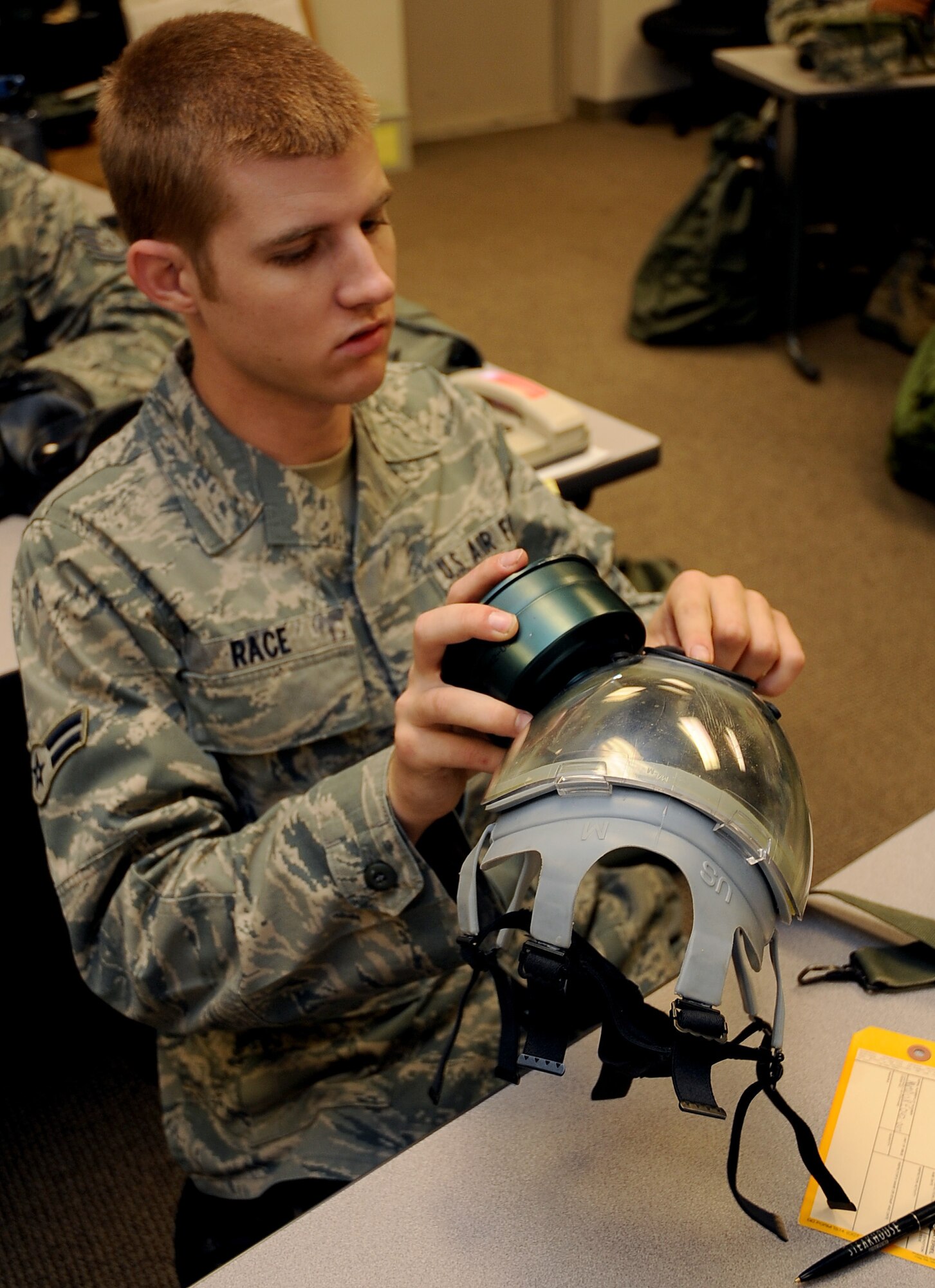 Airman 1st Class Nick Race, 8th Air Force, inspects his gas mask during a chemical, biological, radiological, nuclear and high-yield explosive class on Barksdale Air Force Base, La., Aug. 18. The 2nd Civil Engineer Squadron Emergency Management flight teaches the CBRNE class several times a month to keep Barksdale Airmen up to date with their training requirements. (U.S. Air Force photo/Senior Airman Amber Ashcraft) (RELEASED)