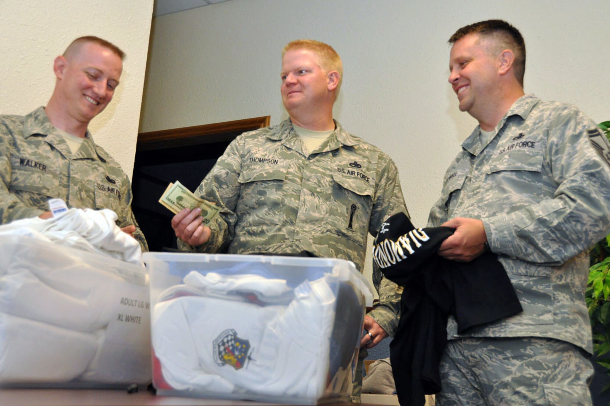 Senior Master Sgt. Rulon Walker, Top 3 vice president, and Senior Master Sgt. Mark Howell, Top 3 president, show Senior Master Sgt. Ralph Thompson, 419th Maintenance Squadron first sergeant, the council’s t-shirts for sale. (U.S. Air Force photo/Staff Sgt. Heather Skinkle)