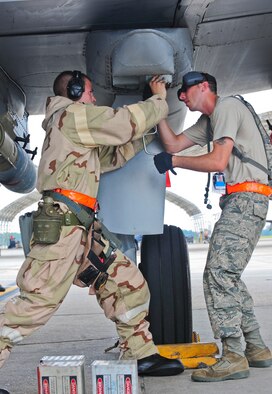 U.S. Air Force Tech. Sgt. Jason Hough and Airman 1st Class Trenton Metyk, 23rd Aircraft Maintenance Squadron weapons armament systems specialists, remove the chaff and flares off an A-10C Thunderbolt II during a phase II operational readiness exercise at Moody Air Force Base, Ga., Aug. 17, 2011. Chaff and flares are defensive mechanisms used to avoid detection and attack by enemy air defense systems. (U.S. Air Force photo by Senior Airman Stephanie Mancha/Released)